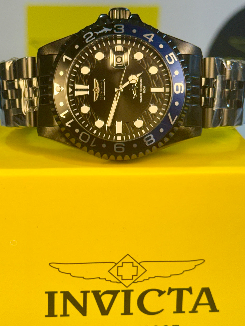 Invicta Mens Pro Diver Black and blue watch with a black face and blue bezel on a yellow box