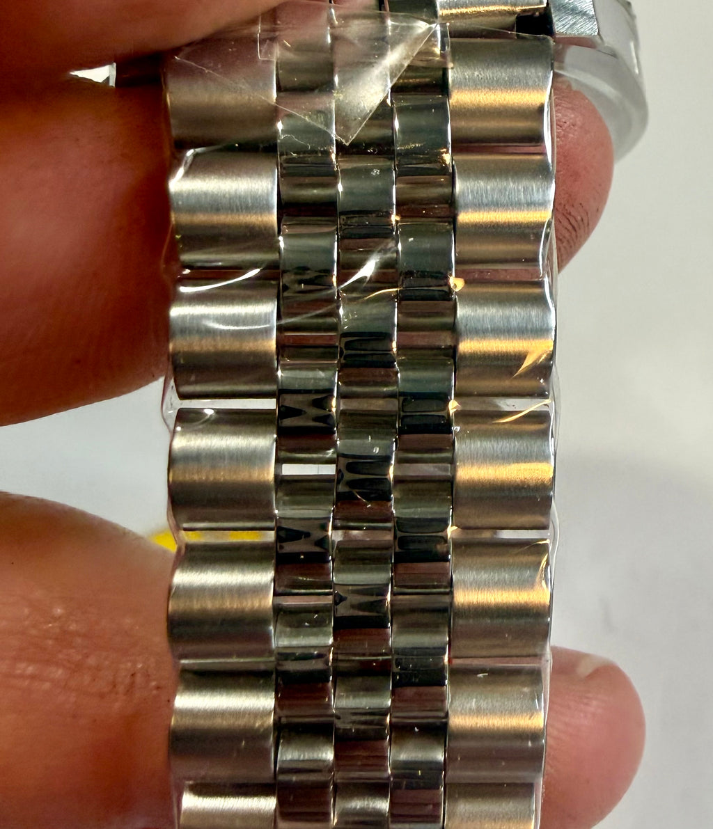 Close-up of a Invicta Mens Pro Diver 43mm Heritage watch bracelet held between fingers