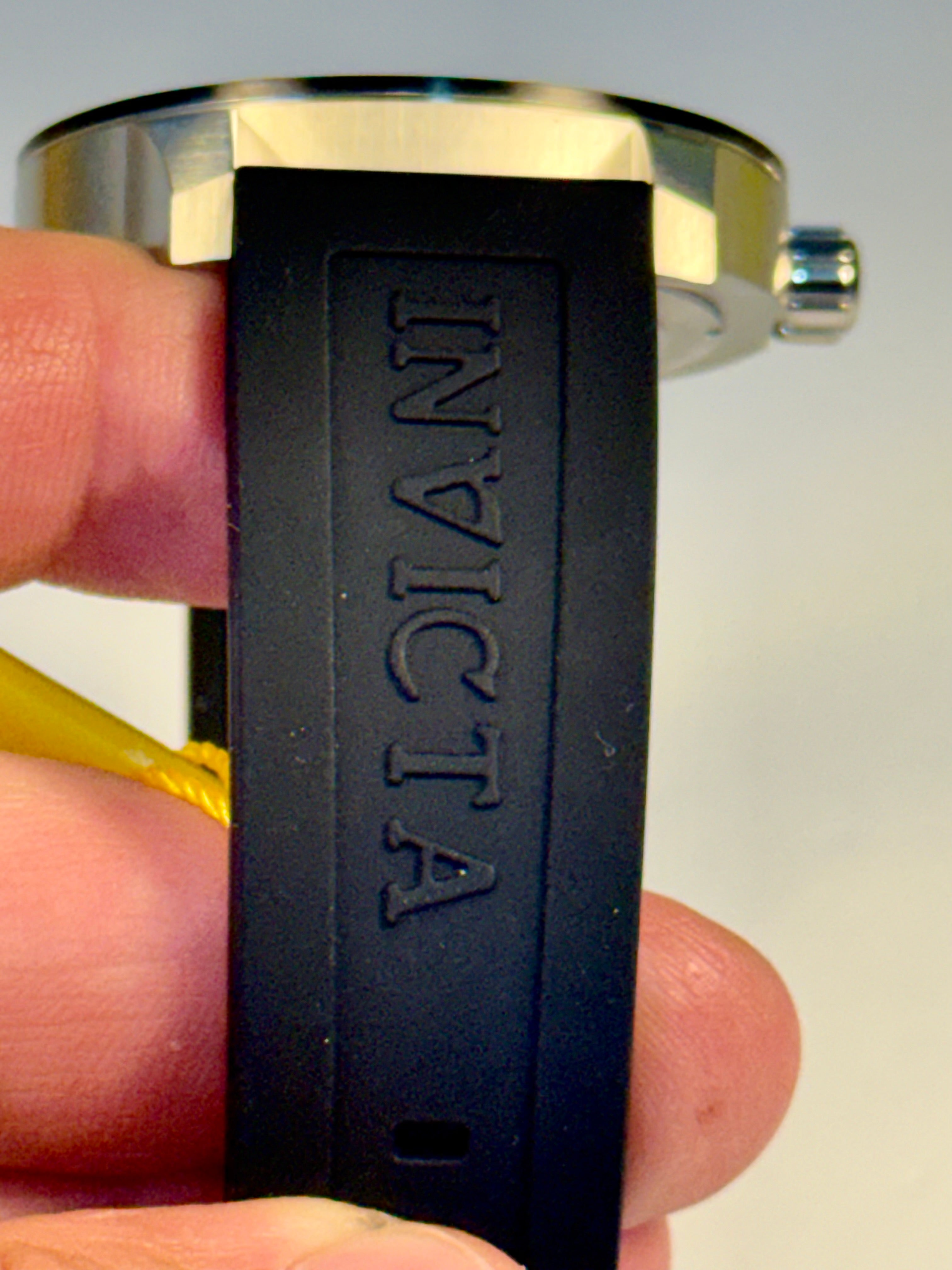 Invicta Specialty Compass'INVICTA' branding held in a hand against a neutral background