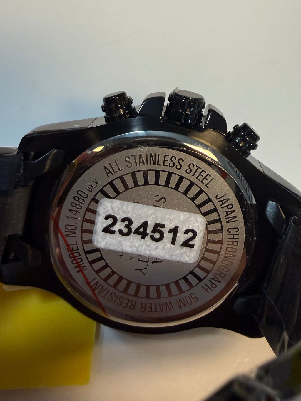 Black wristwatch with visible brand name on a white background