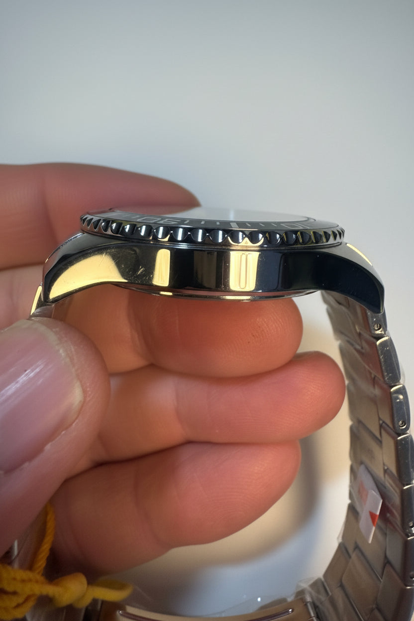 Close-up of a person holding a Invicta Mens Pro Diver silver watch with a textured band.
