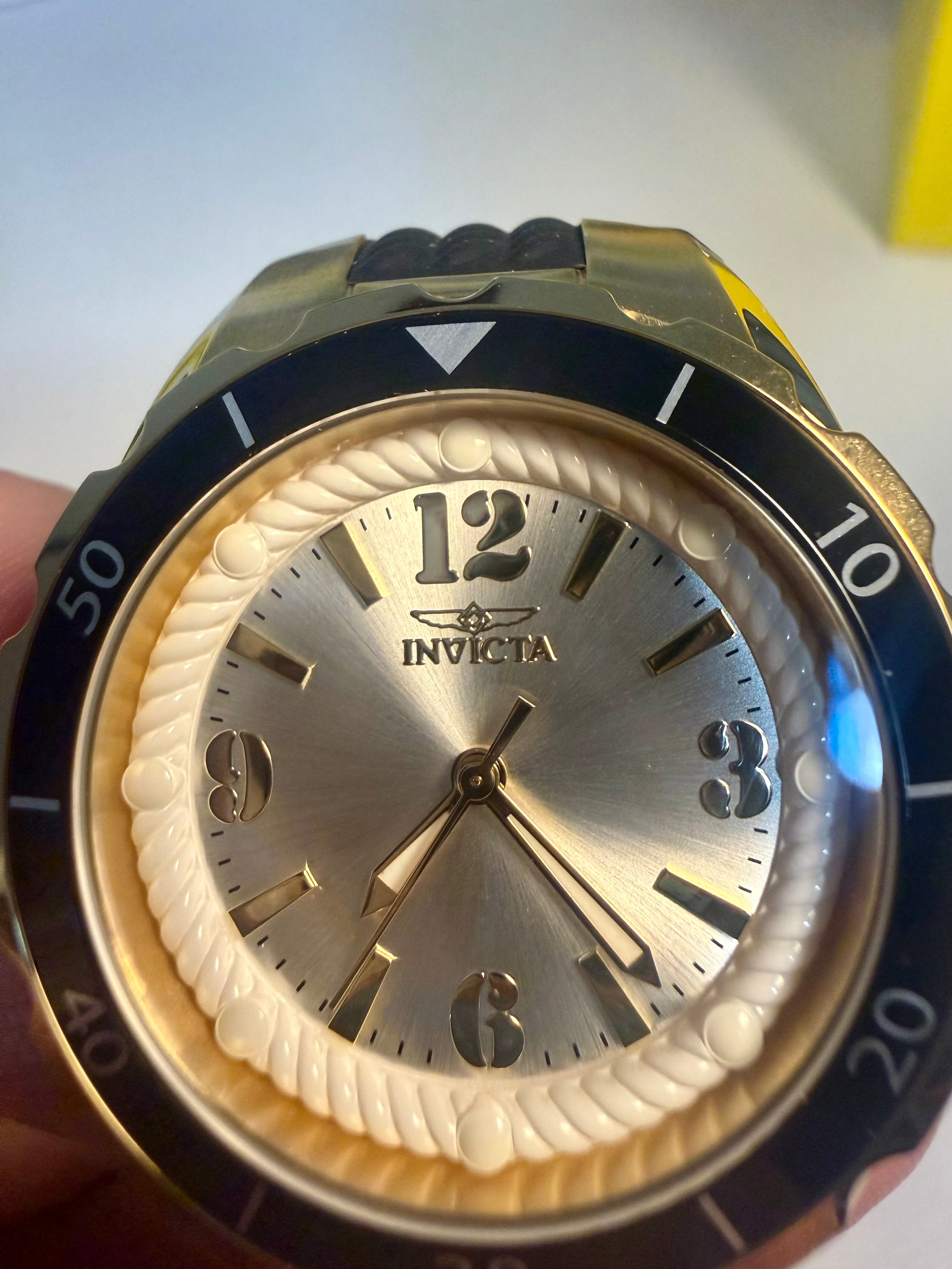 Invicta Ladies Angel watch with gold and black design held by a hand