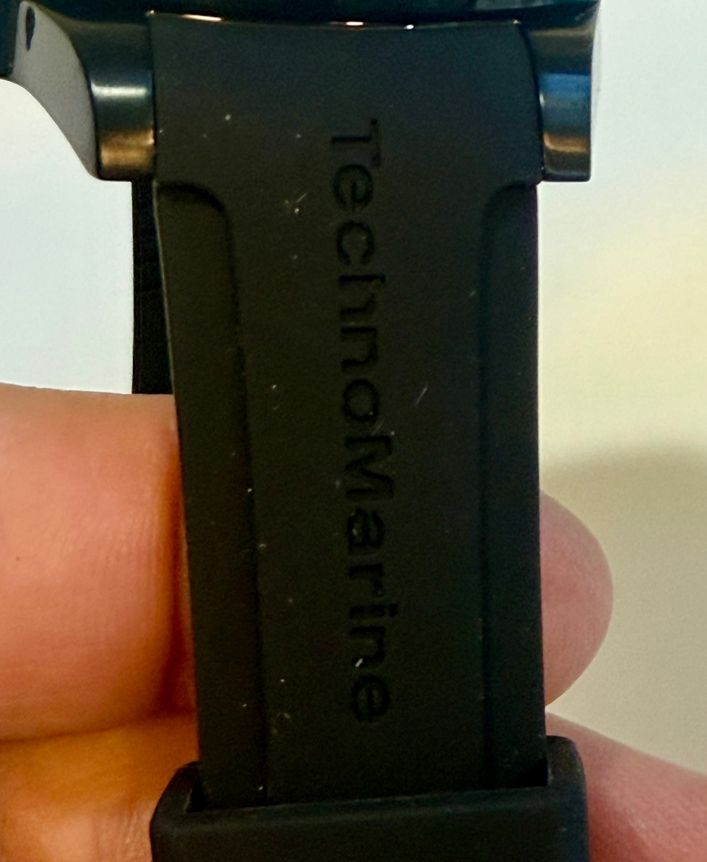 TechnoMarine 42mm Trible Black Manta Sea watch strap with 'TechnoMarine' branding held between fingers.