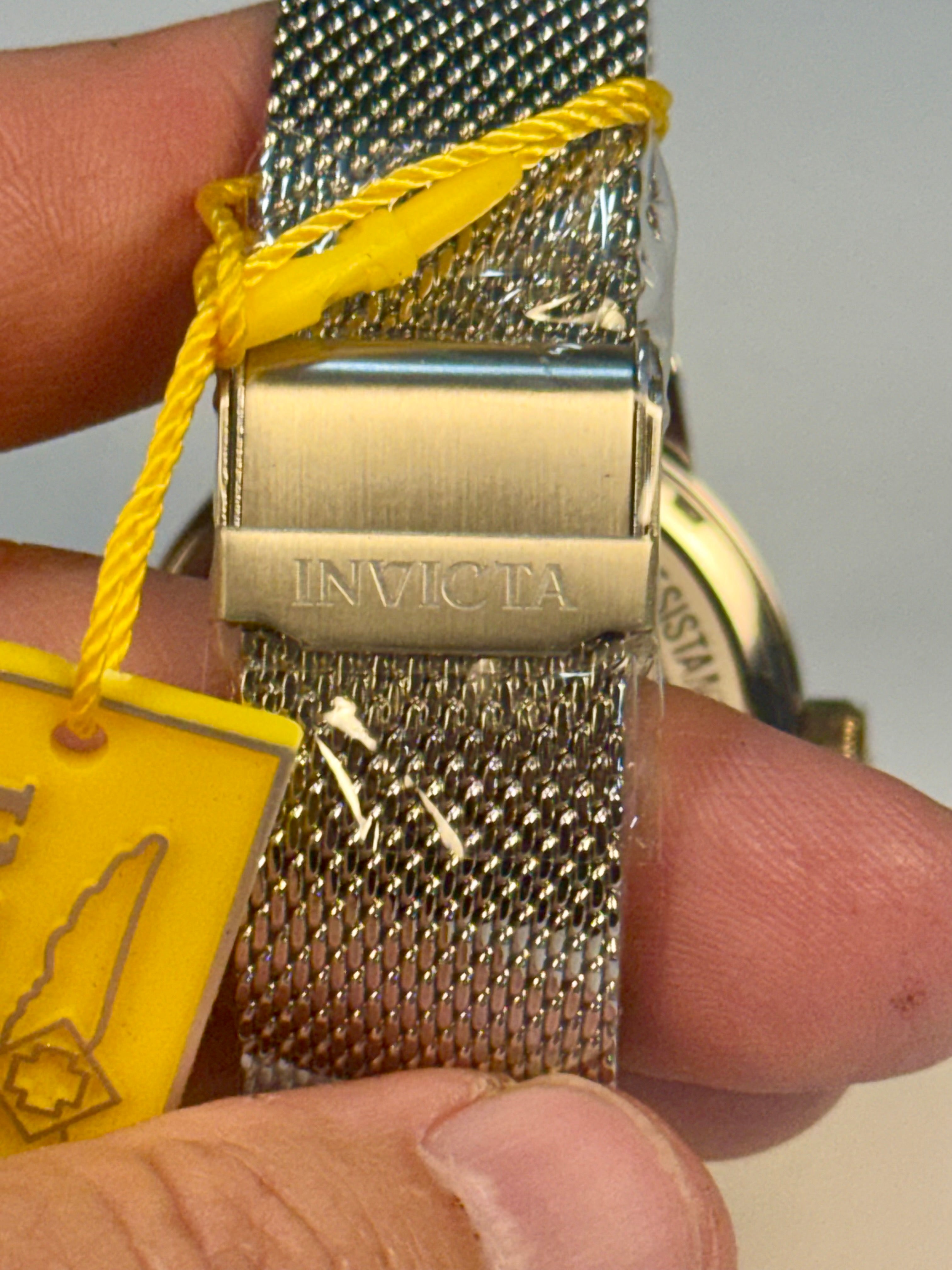 Invicta Mens Specialty watch band held by a hand with a yellow tag in the background