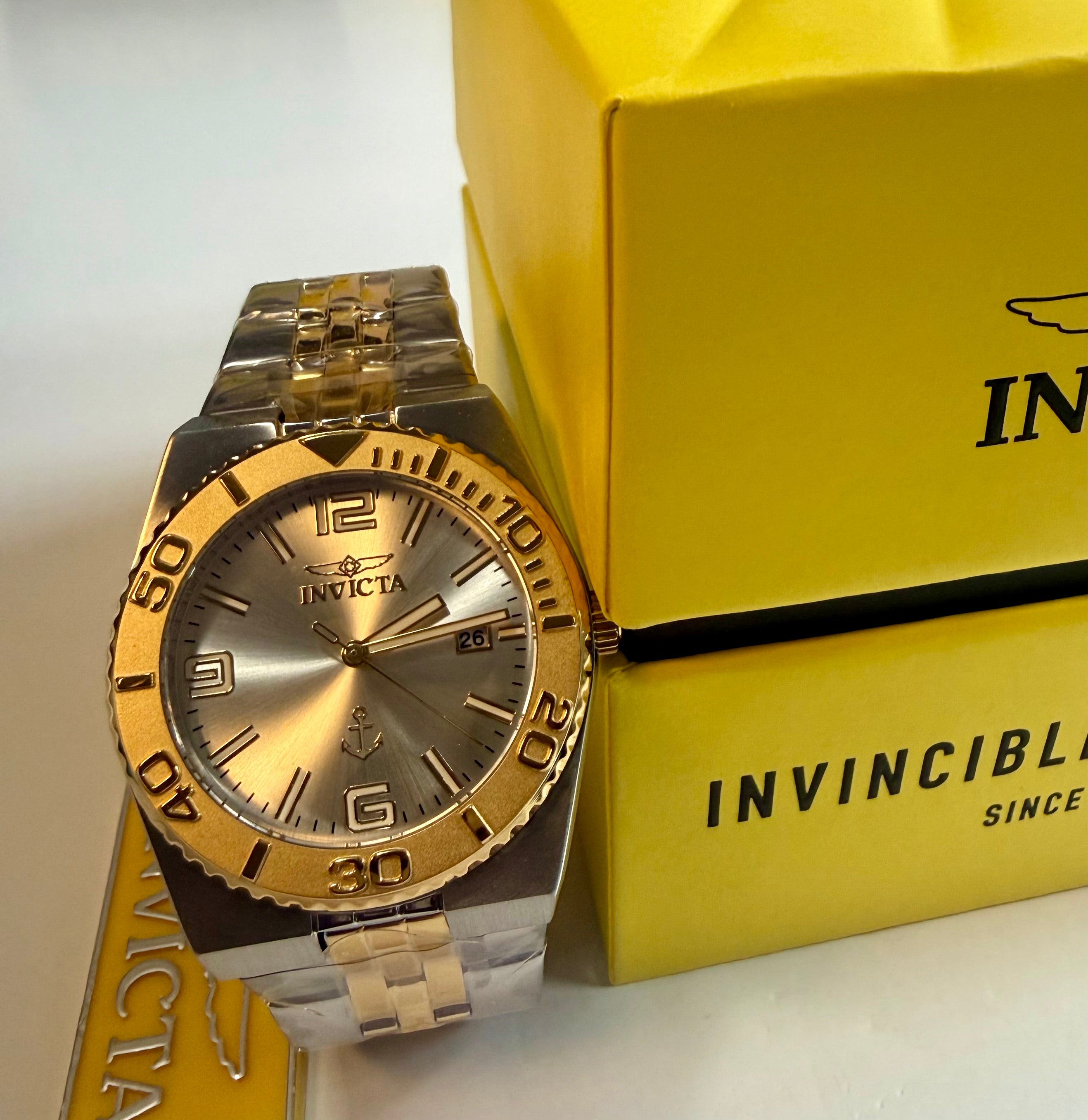 Invicta Ocean Voyage 38mm Pro Diver Gold and silver Invicta watch on a yellow box
