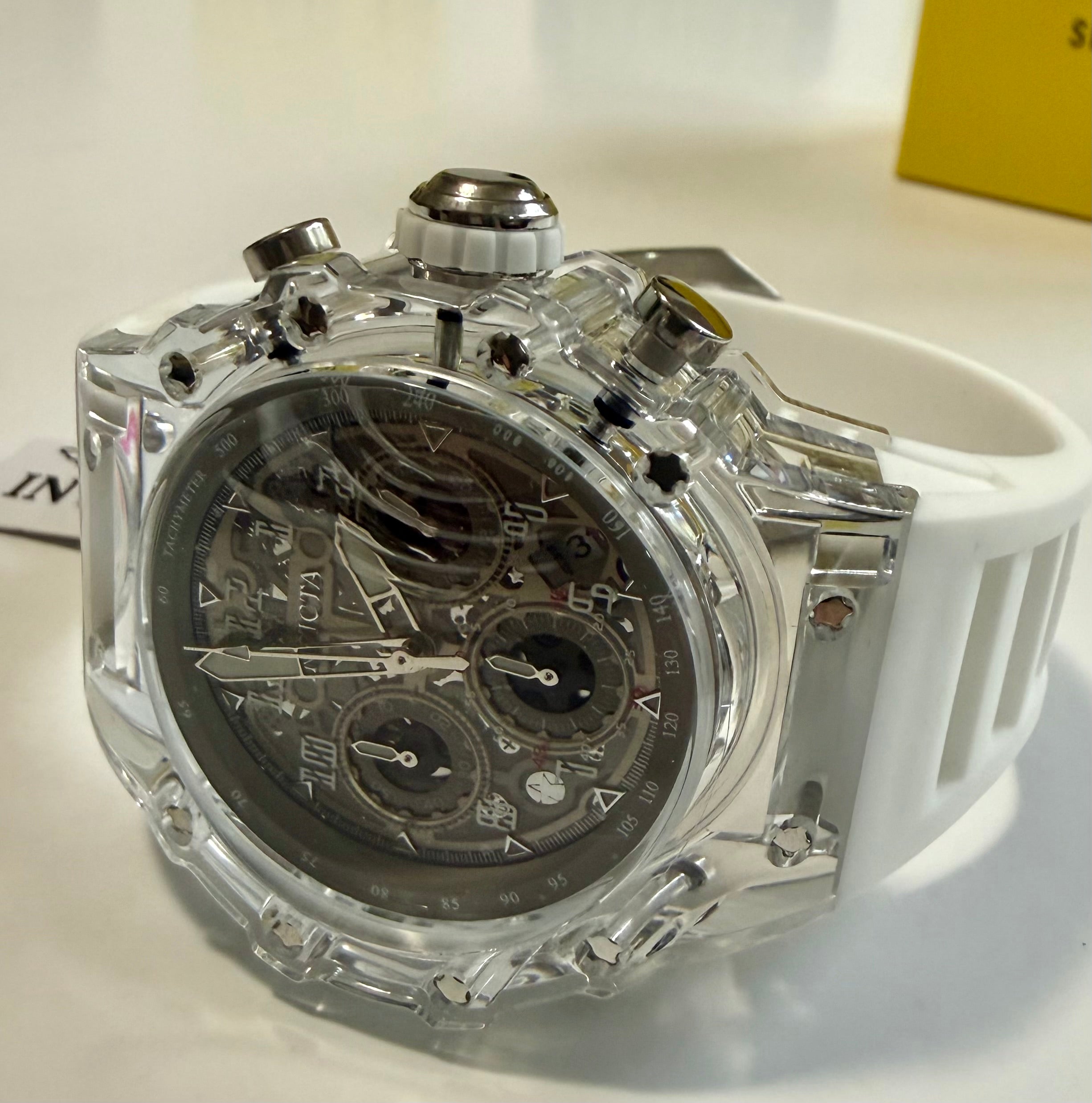 Mens Invicta Racing Vaulthan 44mm Watch with transparent case and white strap on a light background