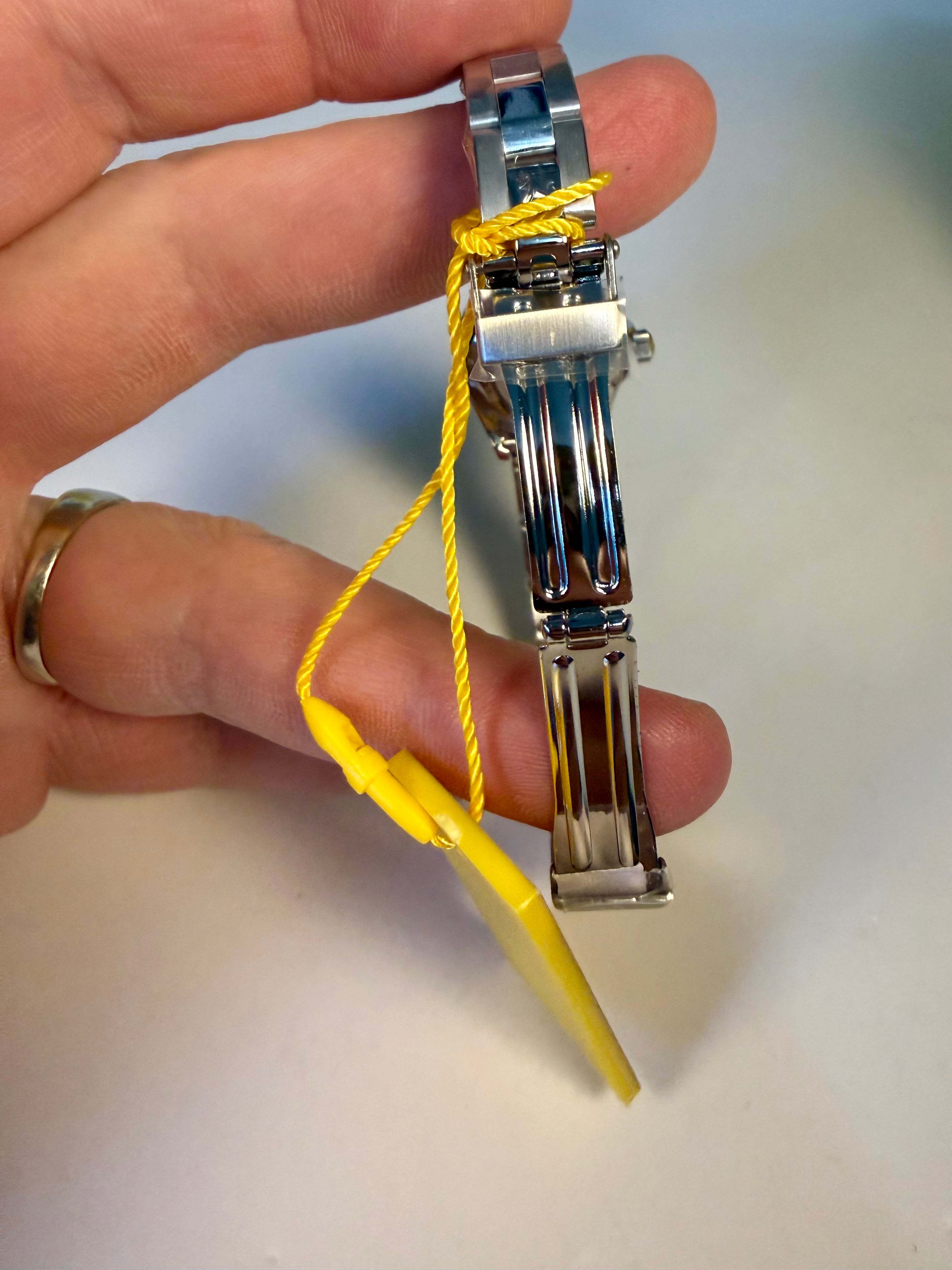 Hand holding a Ladies Pro Diver watch strap with yellow thread against a neutral background