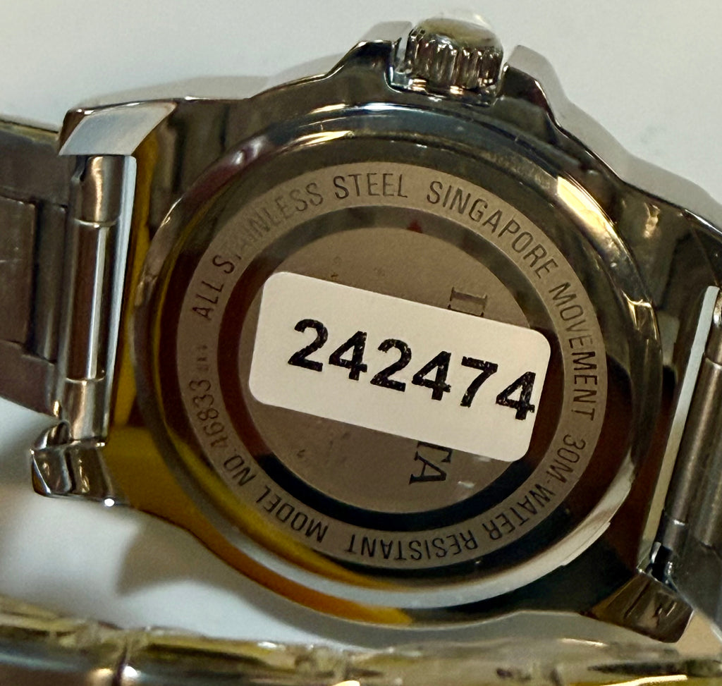 Back of a silver watch with a visible model number label on a white background
