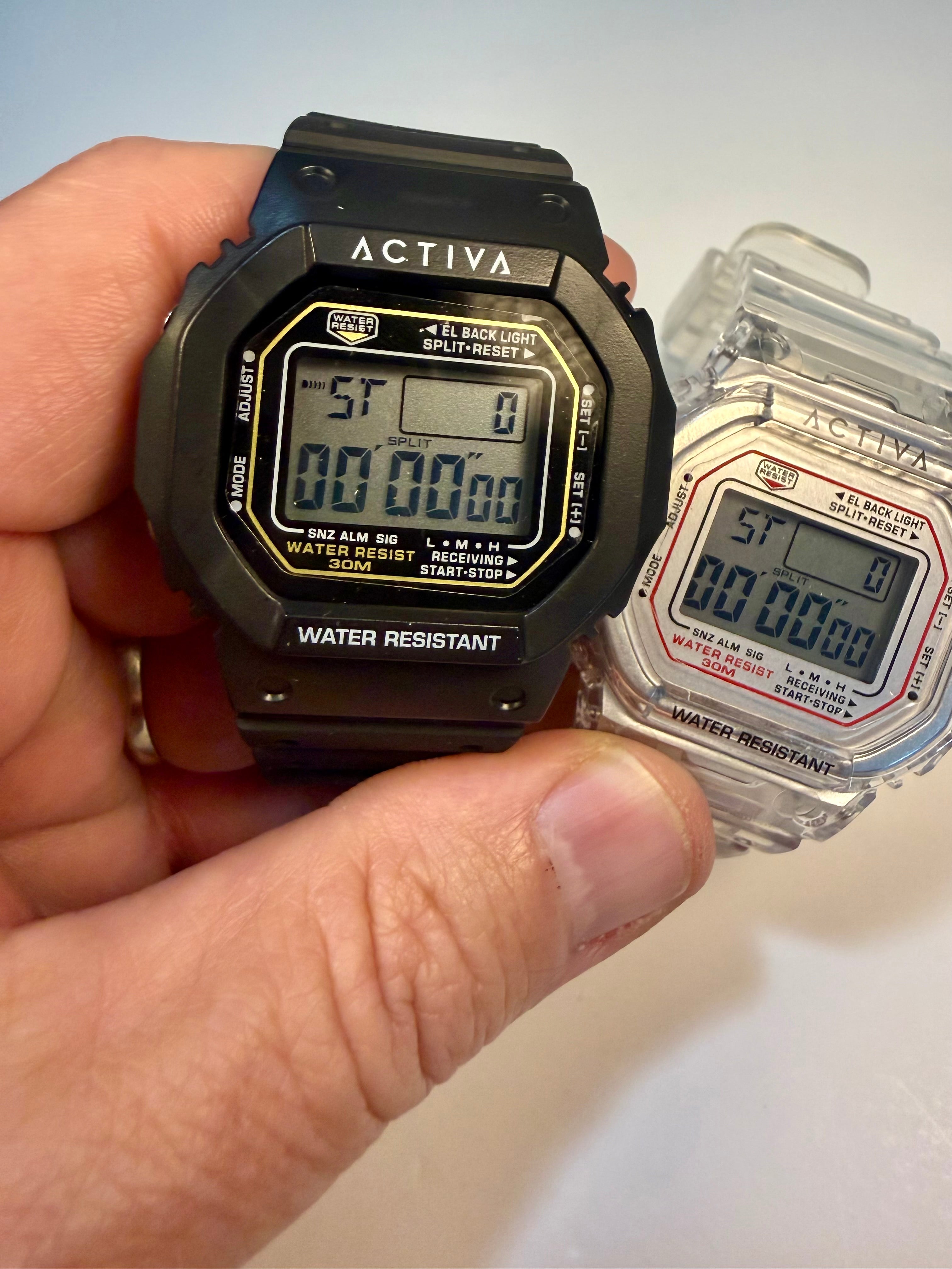 Activa ebony and Ivory Bundle Hand holding a black digital watch with 'Activa' branding, next to its packaging.