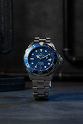 Invicta 47mm Ocean Voyage Wristwatch with blue dial and silver metal strap on a light gray background