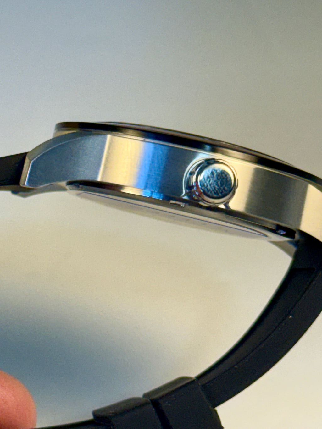 Close-up of a Invicta Specialty Compass with a metallic band and black strap on a neutral background