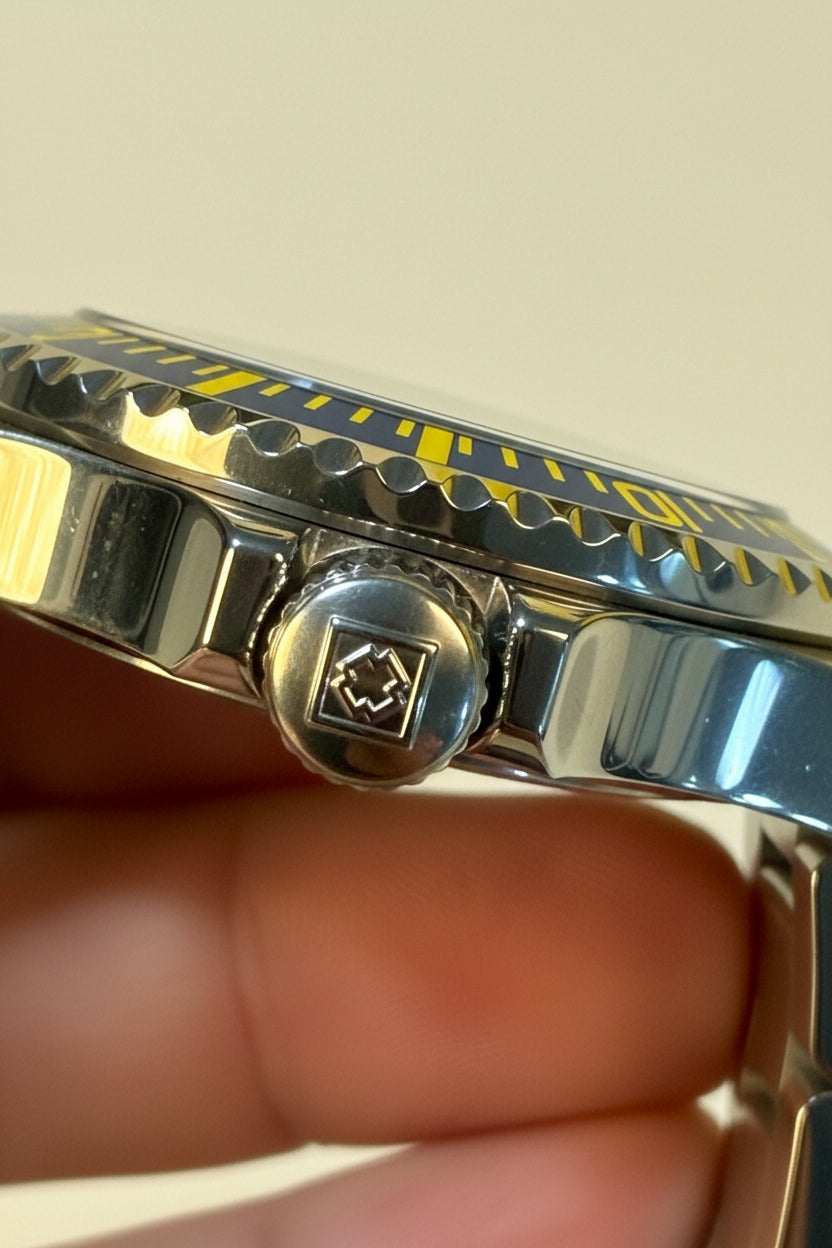 Close-up of a Invicta Mens Pro diver Aurenova 40mm   silver watch case with a brand logo on a beige background