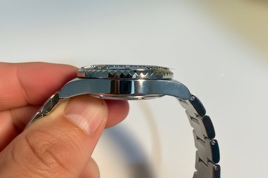 Close-up of a person holding a Invicta Pro Diver 12819 Swiss Ronda 515 40mm 0.06ctw Diamondsilver watch with a blue strap.