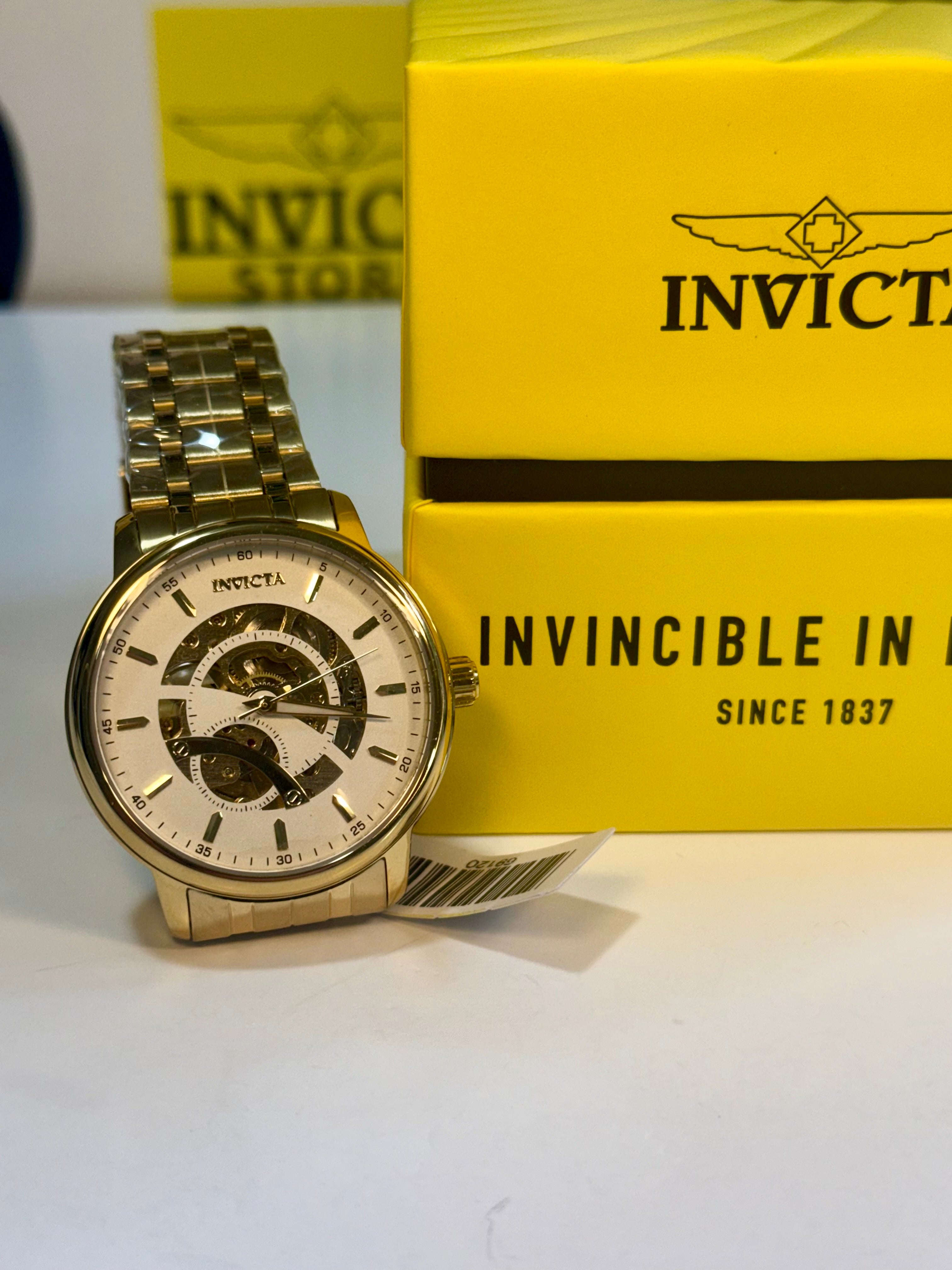 Invicta Mens Automatic Objet' De Art  Gold watch with Invicta packaging on a white background