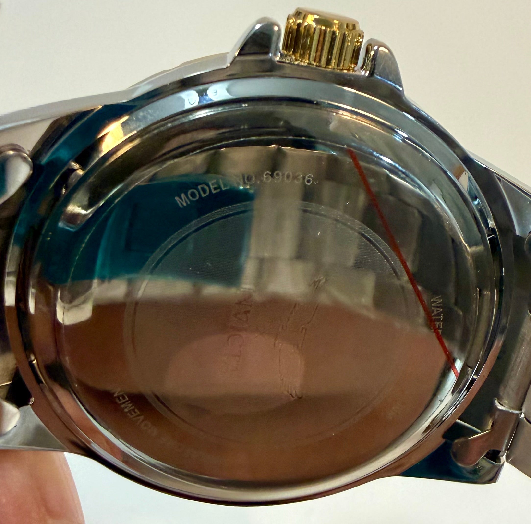 Close-up of a watch case with visible branding on a white background