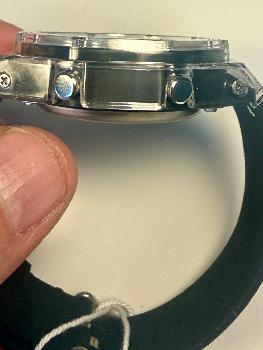 Close-up of a Activa Kaleido Rainbow  watch band with a person's hand holding it against a white background