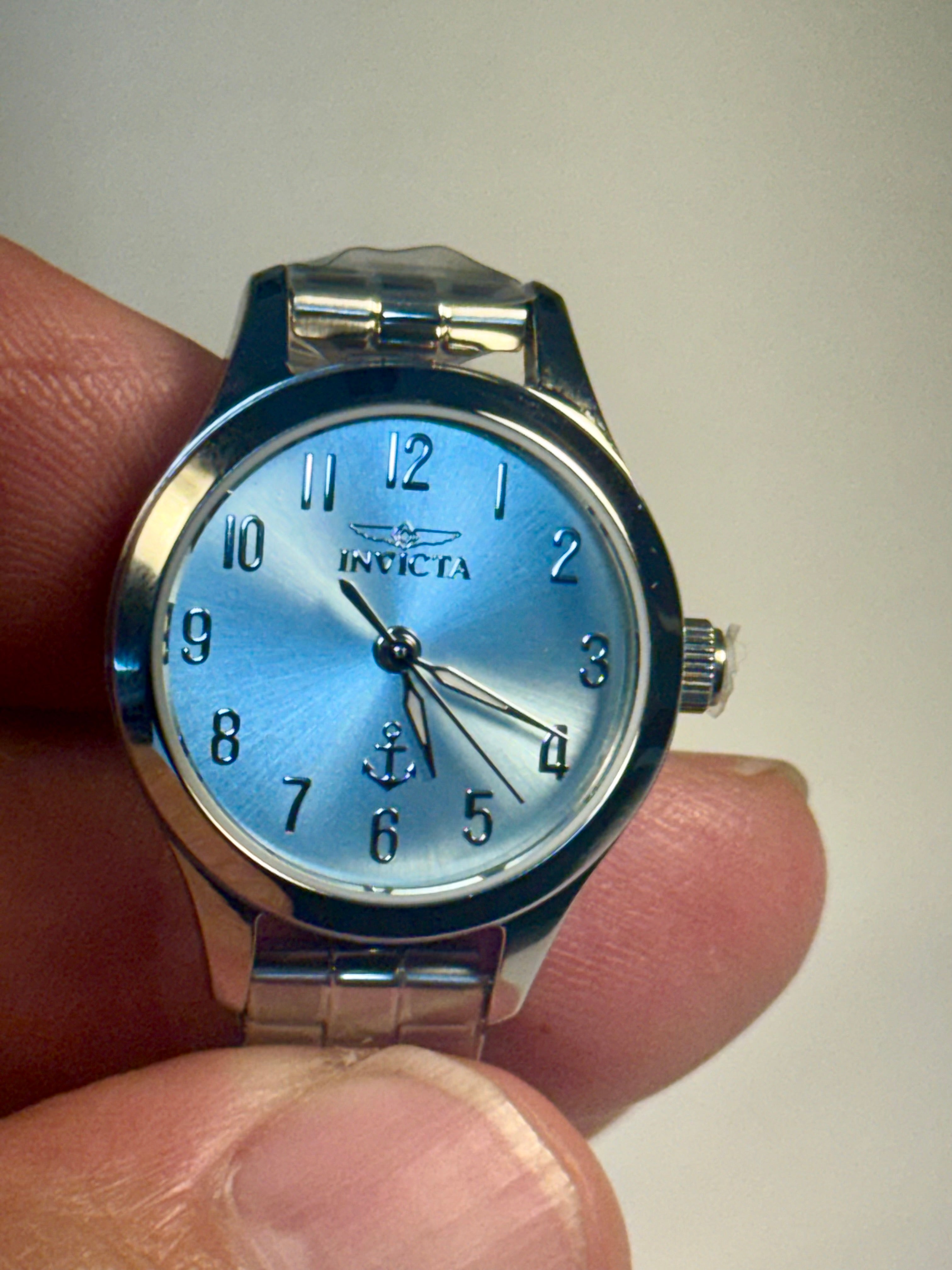 Invicta Ladies Ocean Voyage Silver watch with blue face held in hand against a plain background