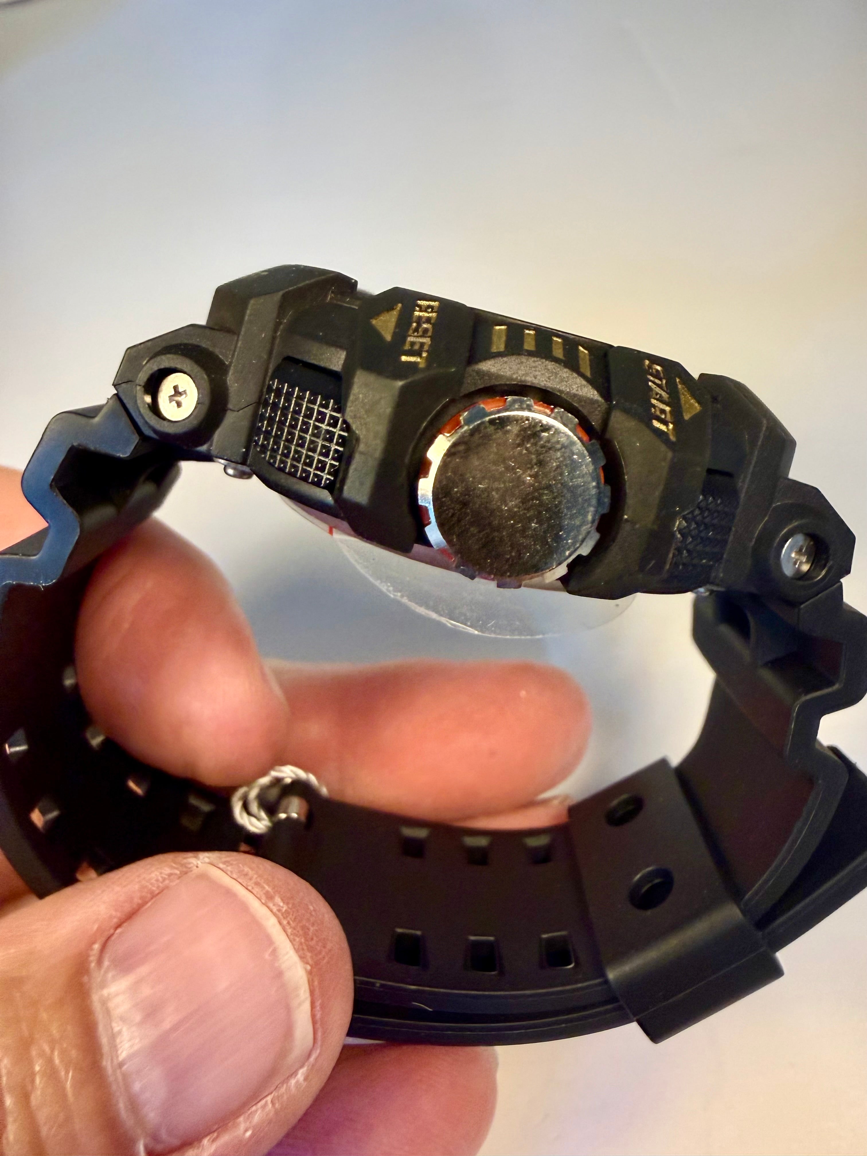 Close-up of a black Invicta Activa Vord X watch being held by a hand on a light gray background