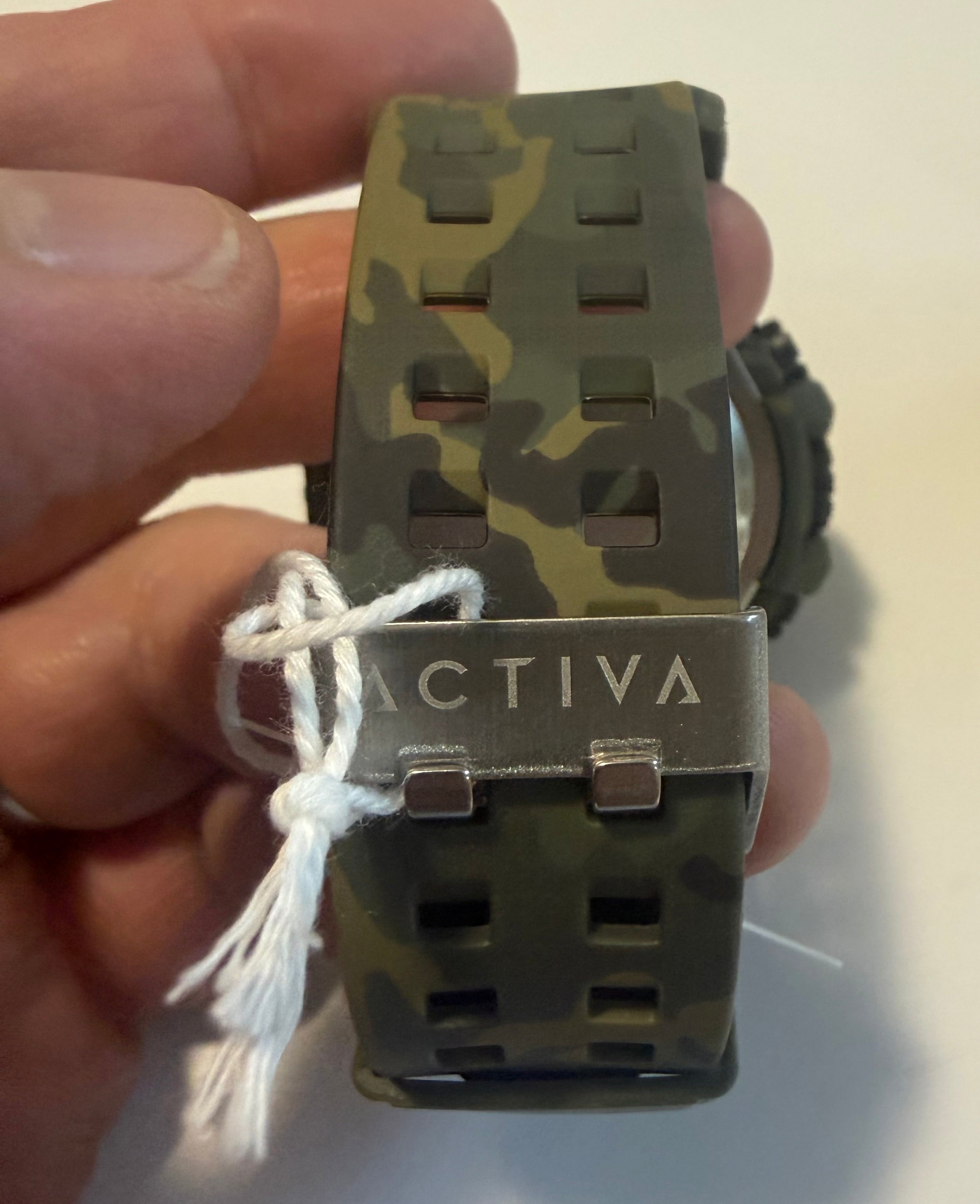 Activa X By Invicta Camouflage watch band with 'Activa' branding held in a hand against a neutral background