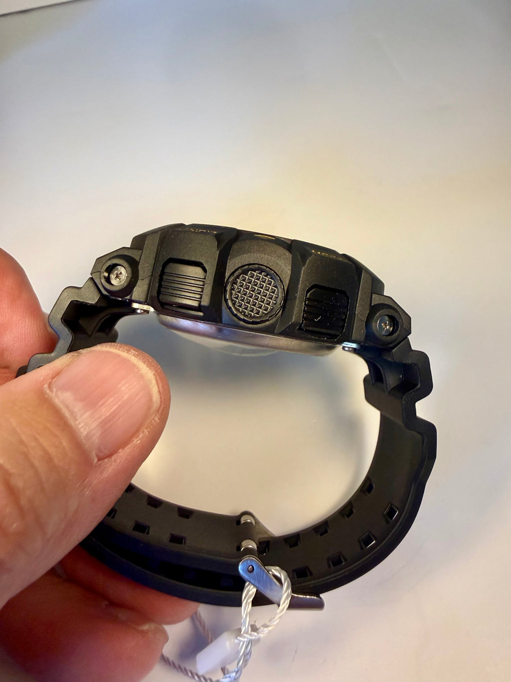 Close-up of a Invicta Activa Vord X with a keychain attachment held by a hand on a white background