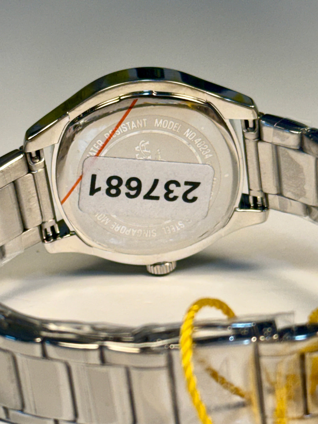 Close-up of aI nvicta Ladies Wildflower watch with a visible model number on a gray background