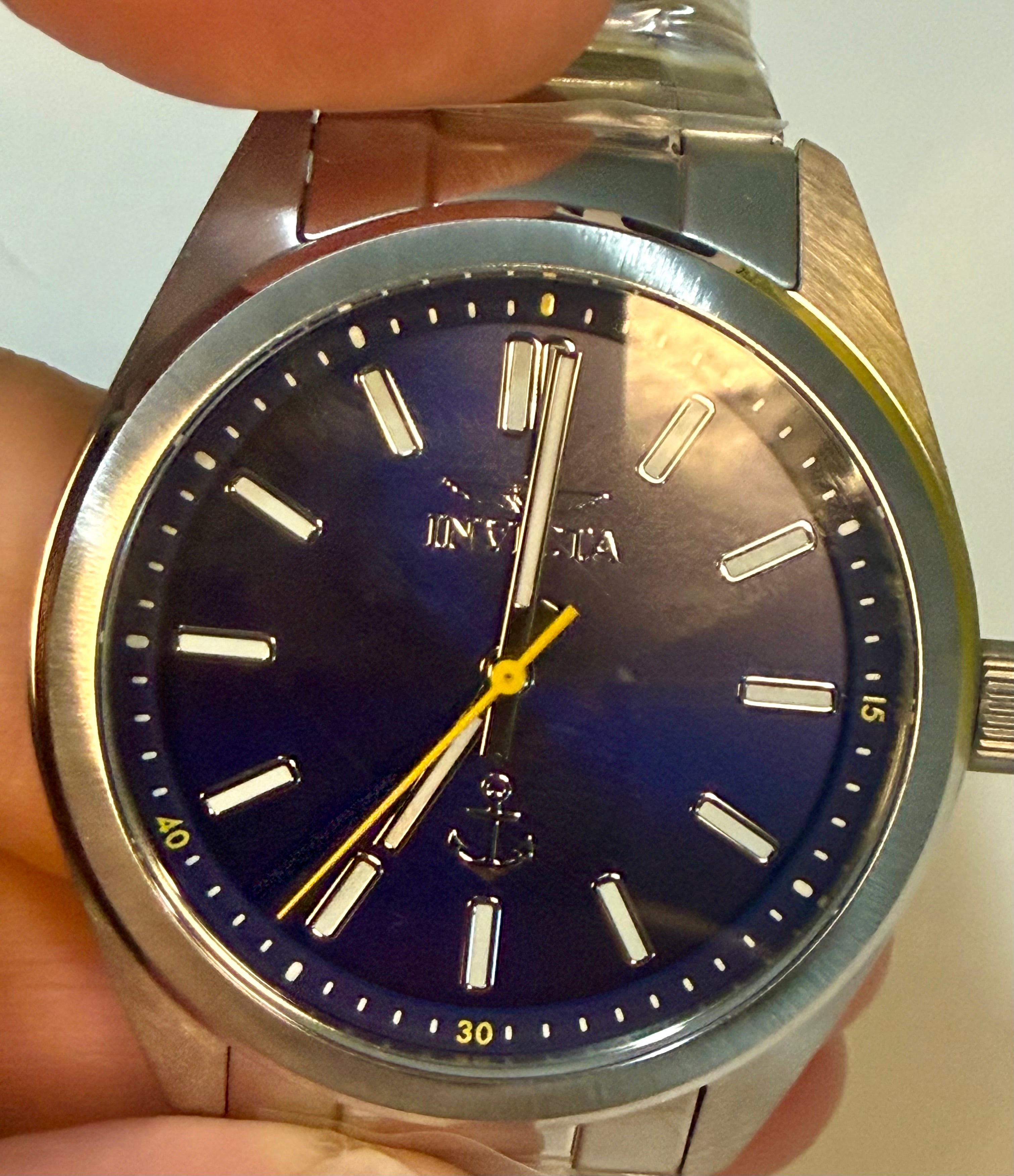 Invicta Ocean Voyage 41mm watch with blue dial and gold accents held in a hand.