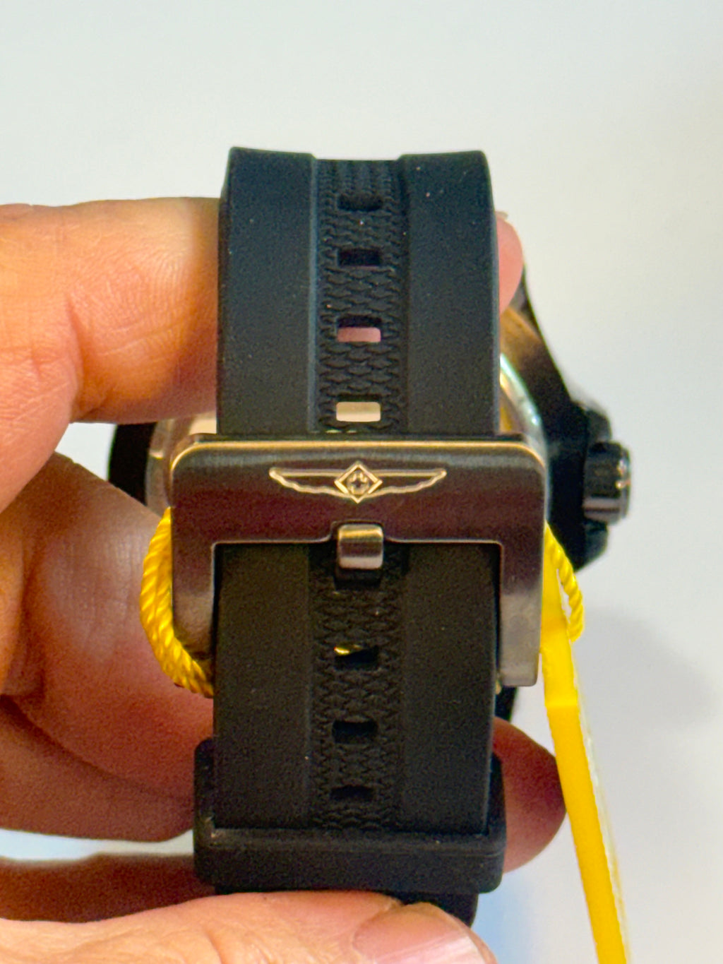 Close-up of a Invicta Mens Pro Dvider Chronographwatch strap being adjusted on a wrist with a white background