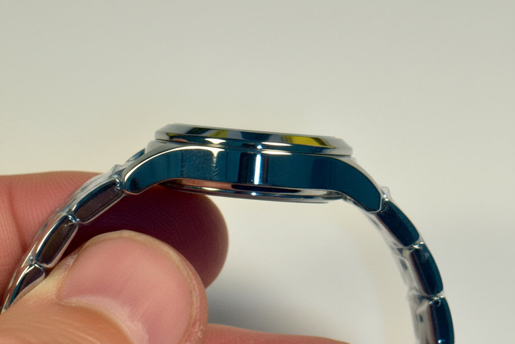 Close-up of a Invicta Ladies Ocean Voyagewatch band held by a hand against a white background