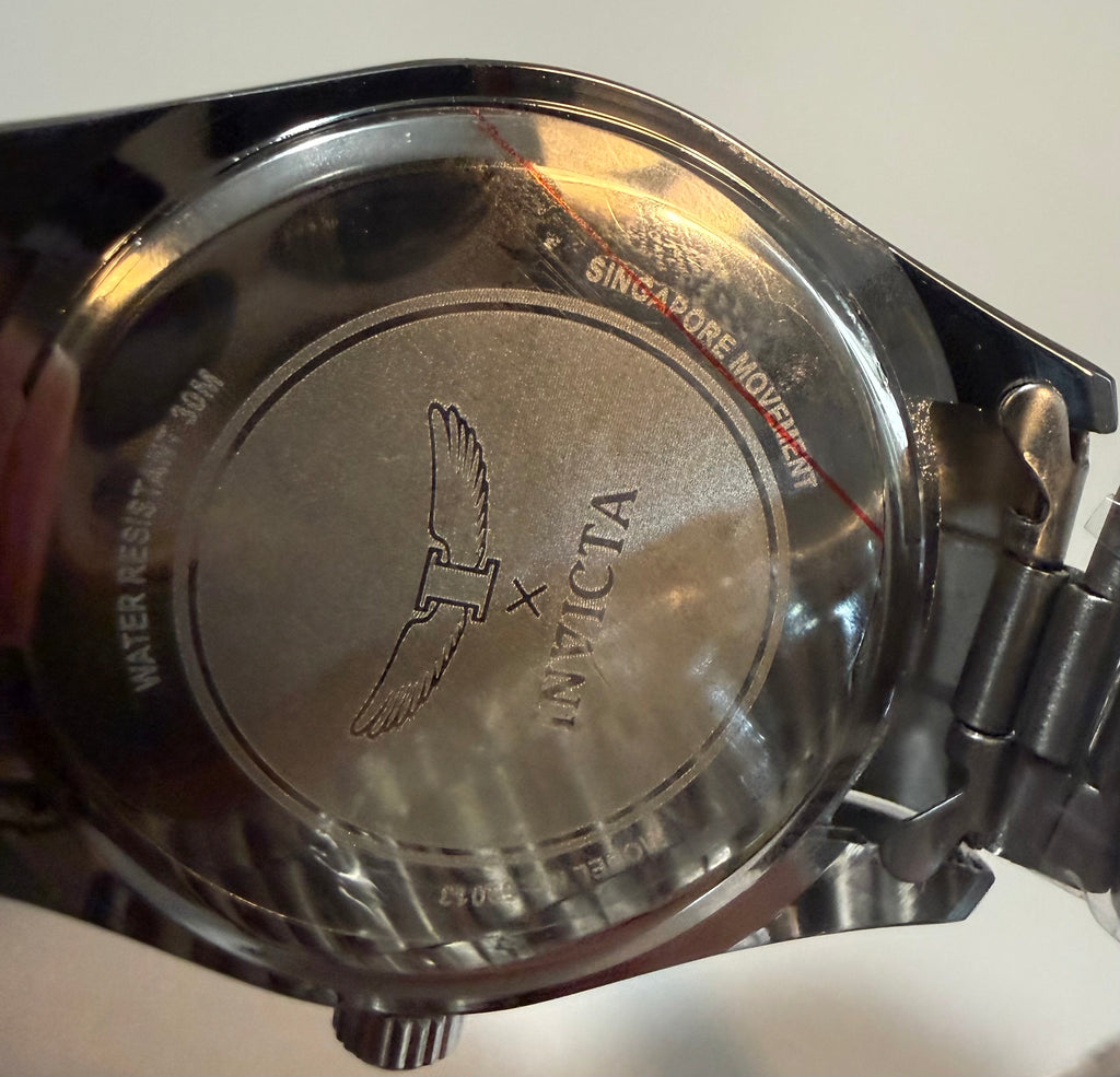 Close-up of a watch case with Invicta branding on a white background