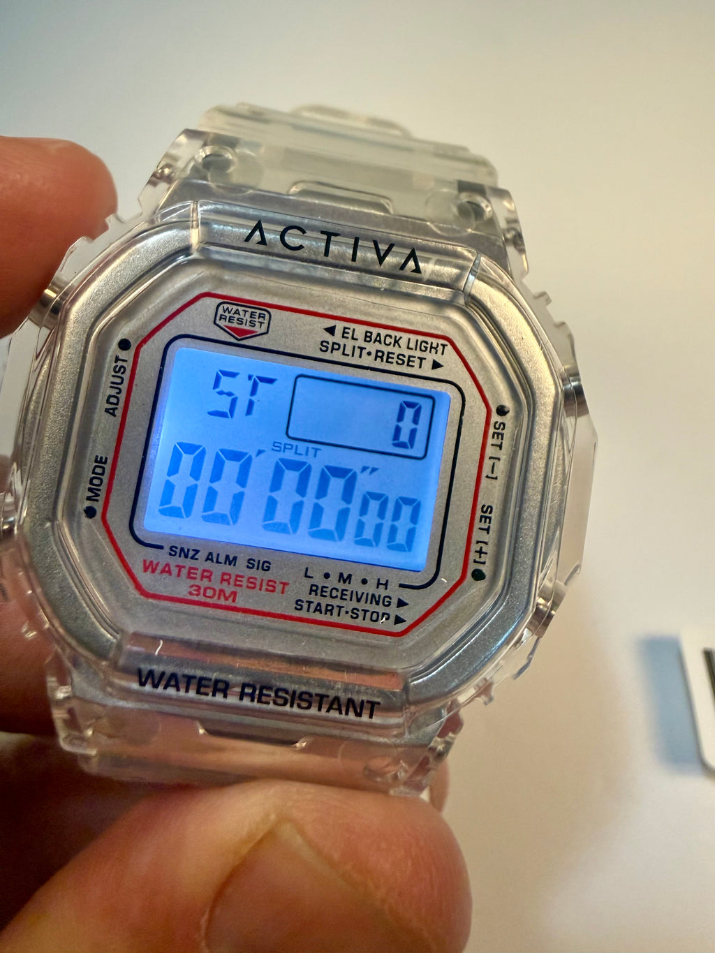 Activa ebony and Ivory Bundle Digital watch with clear case and visible brand 'Activa' held by a hand.