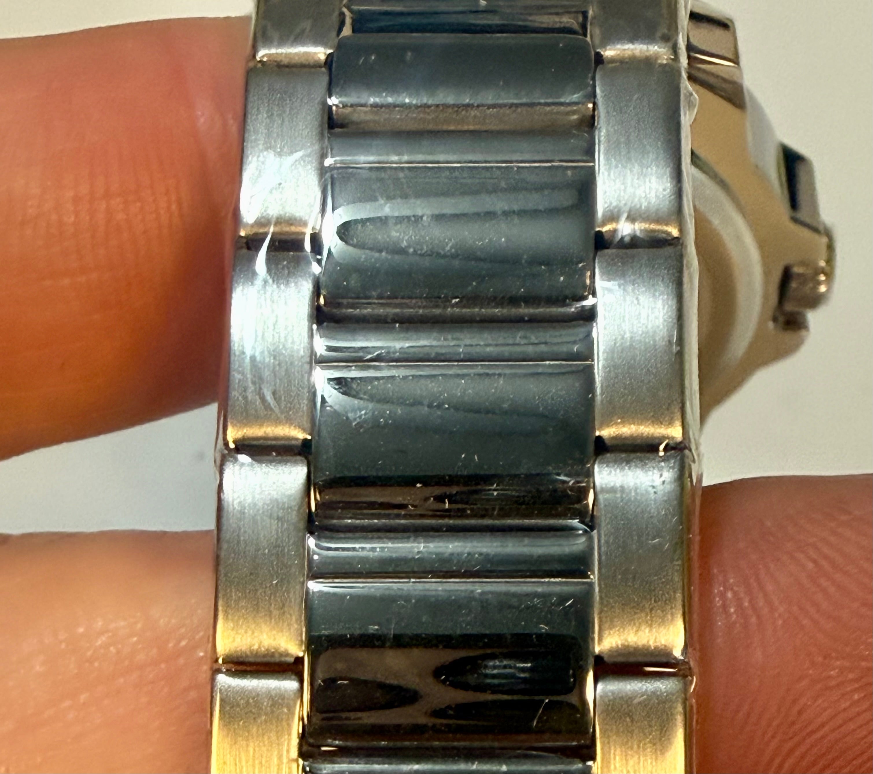 Close-up of a Mens 42mm Invicta Speedway Dominus silver watch band on a person's wrist