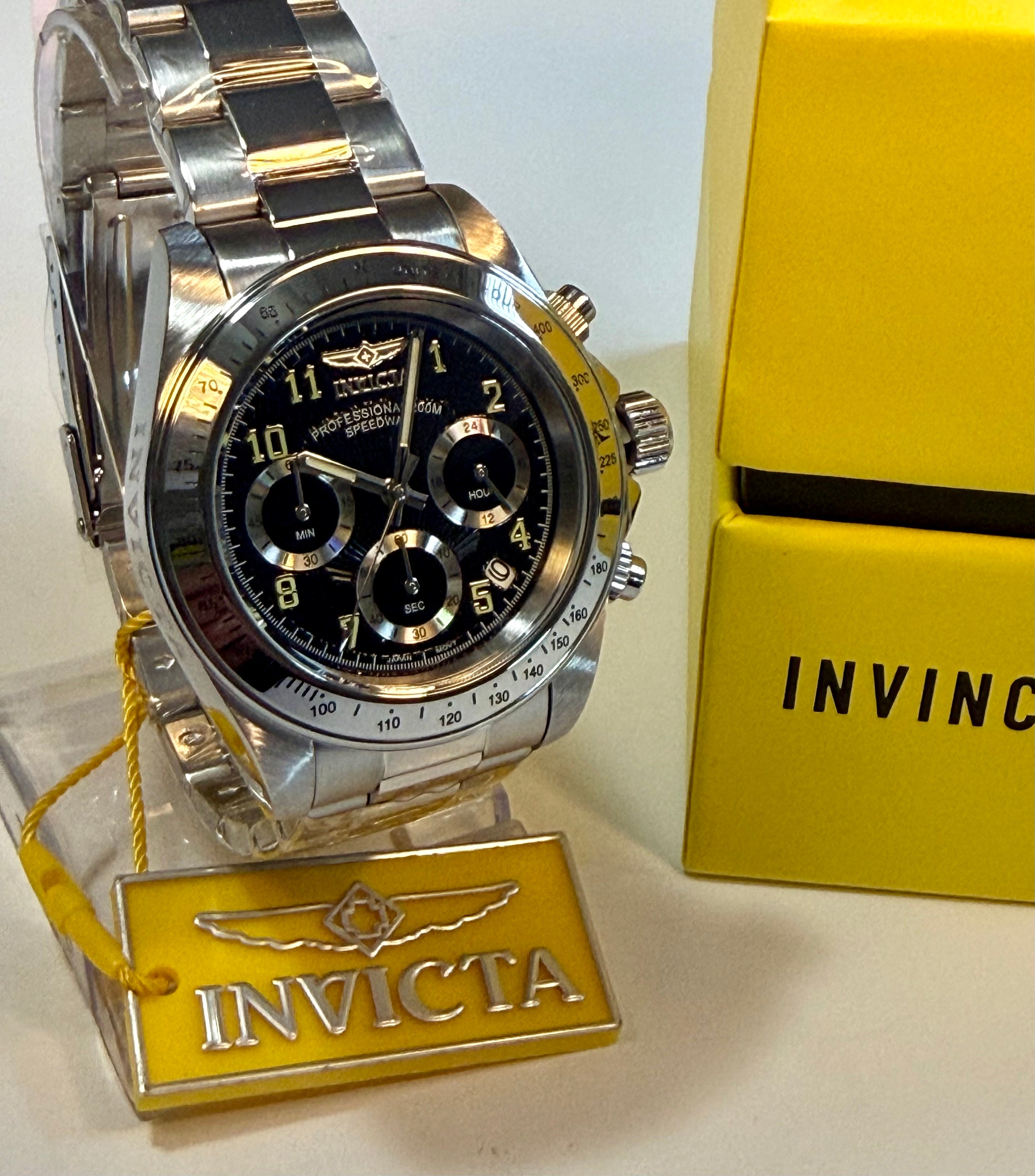 Invicta Speedway Torvane 17025 Men 39.5mm Chrono Steel Watch Black Textured Dialwith black face on a stand next to a yellow box