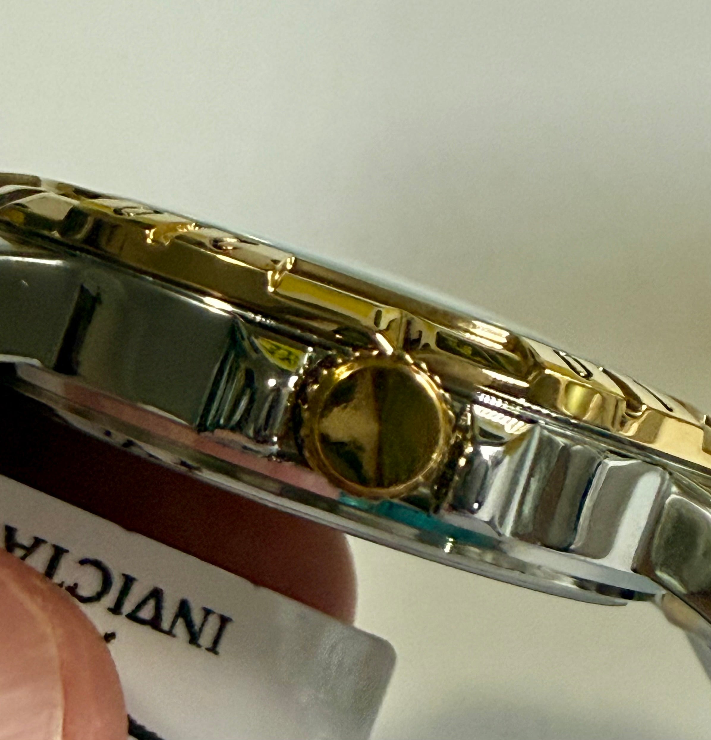 Close-up of aInvicta Specialty I Mens 42mm gold and silver watch with a blurred background