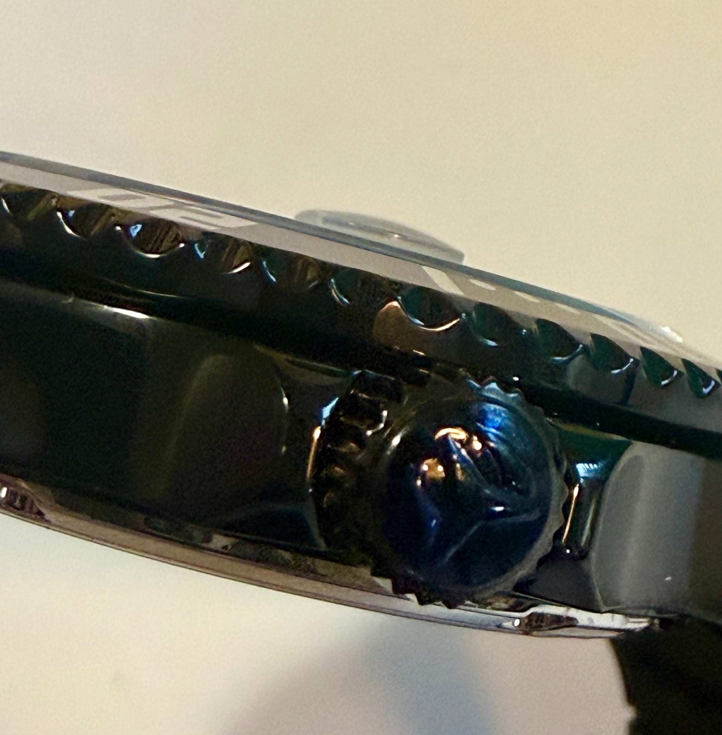 Close-up of a watch strap with metallic finish on a light background