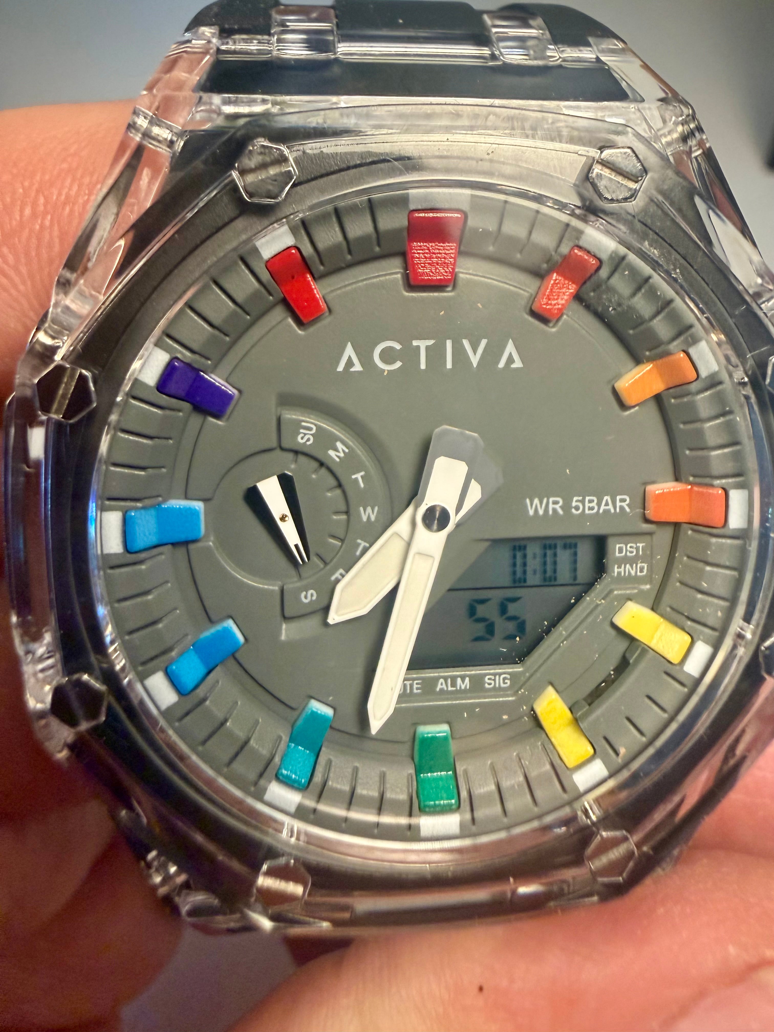 Activa Kaleido Rainbow watch with colorful button accents held in a hand