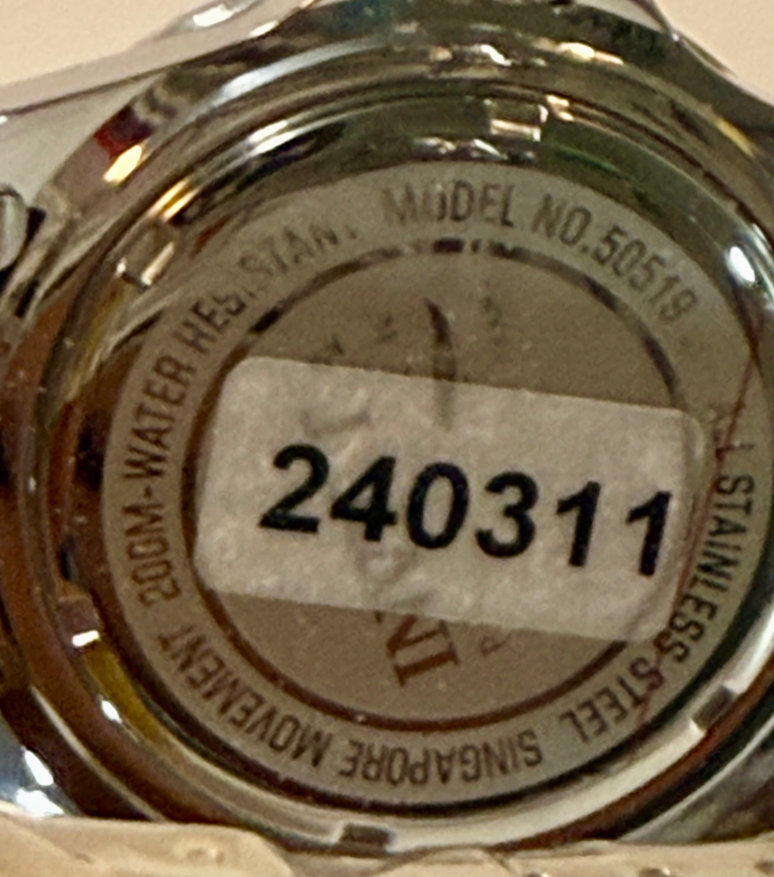 Close-up of a watch case with model number 50519 and serial number 240311.