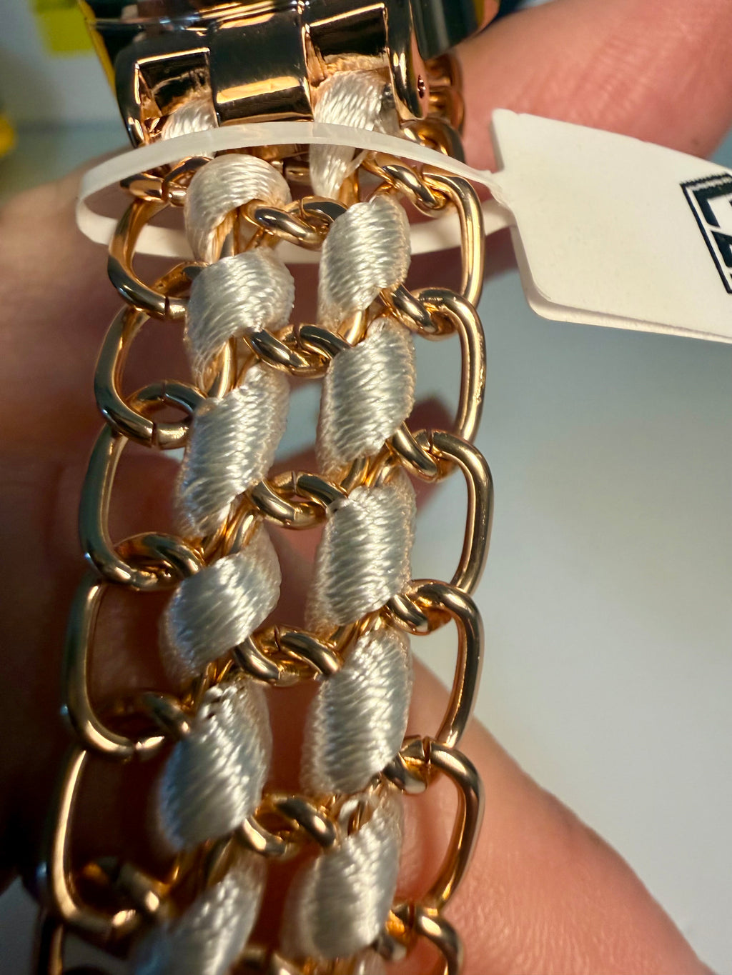 Ladies Montres Prestige Gold chain bracelet watch held by a hand with a blurred background