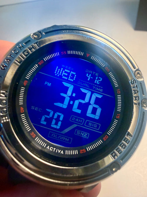 Activa Voyager Digital watchwith blue screen displaying time and date, held by a hand.