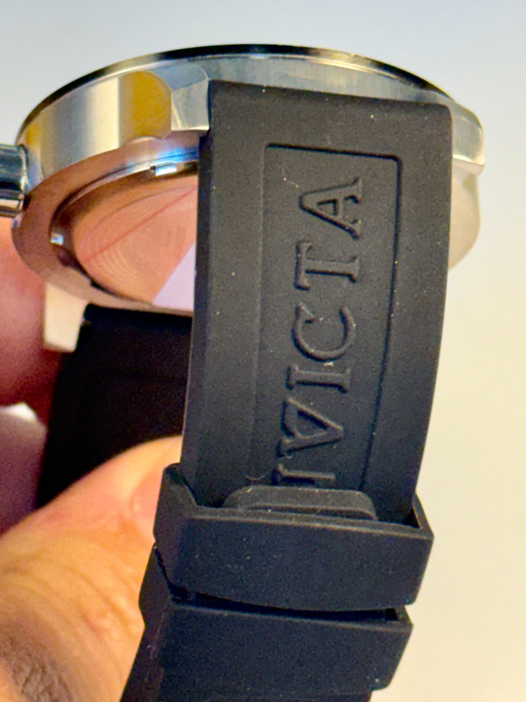 Invicta Specialty Compass with 'Invicta' branding held by a hand against a neutral background