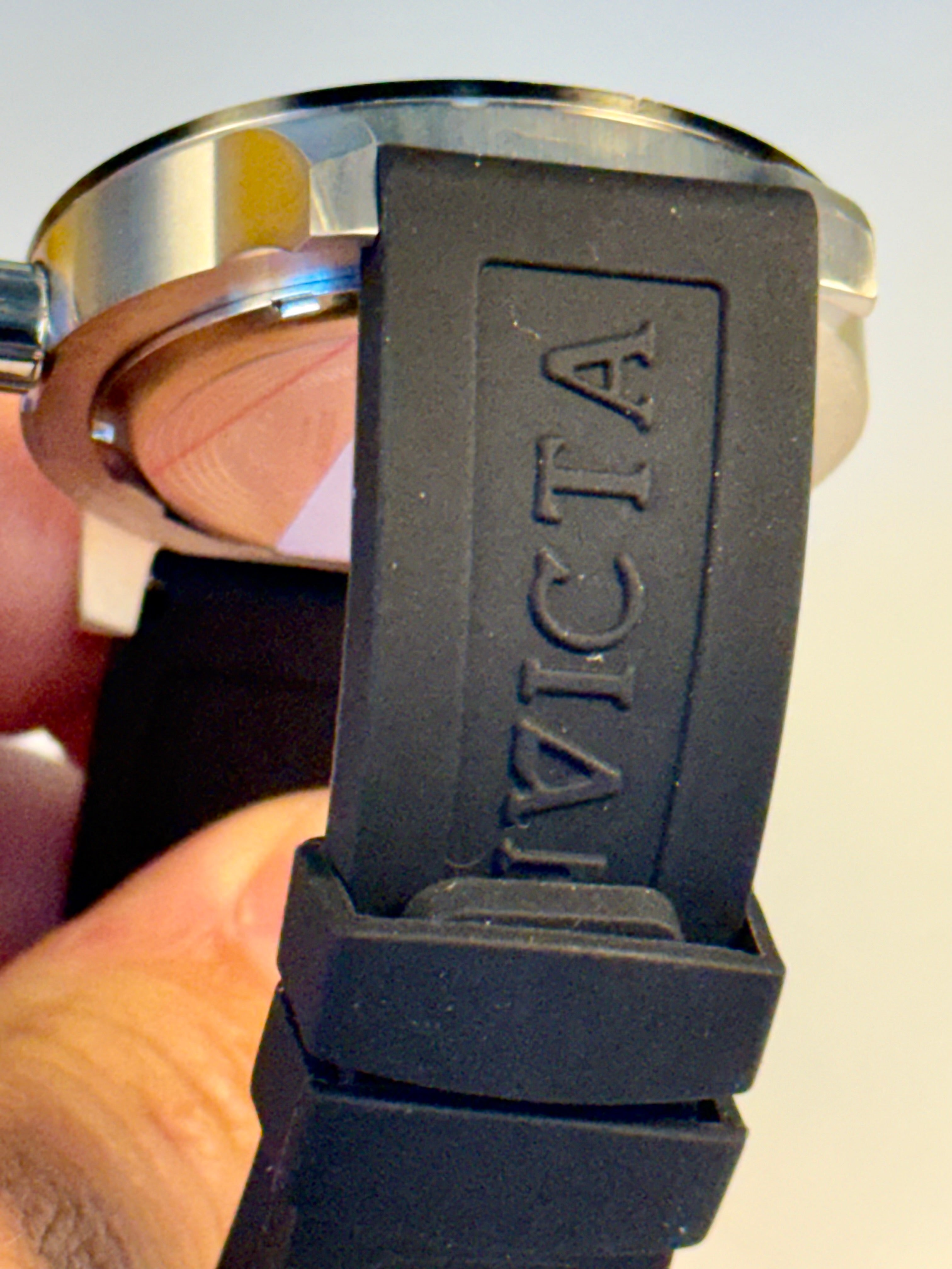 Invicta Specialty Compass with 'Invicta' branding held by a hand against a neutral background
