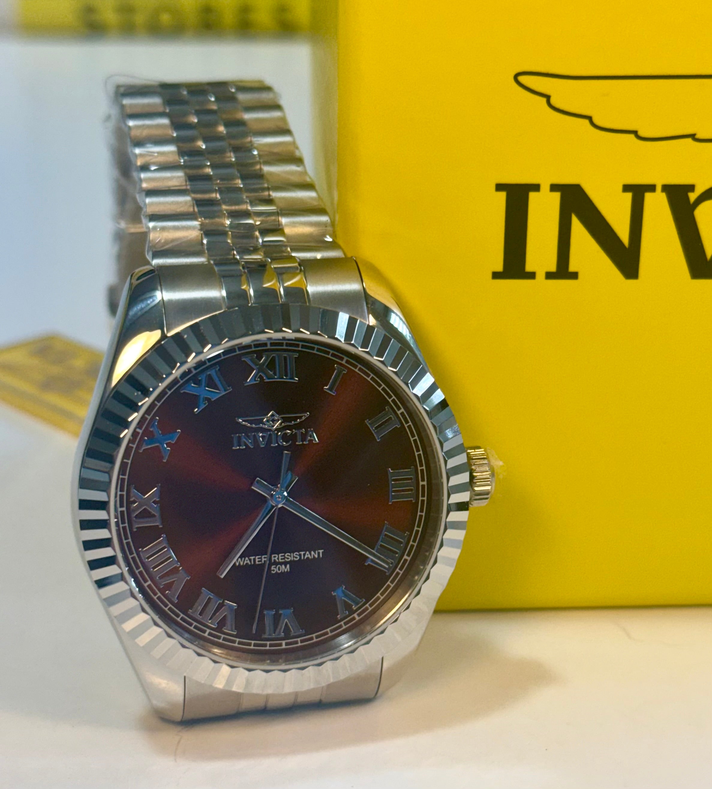 Invicta Specialty Windsor 43mmwatch with a dark face on a yellow background