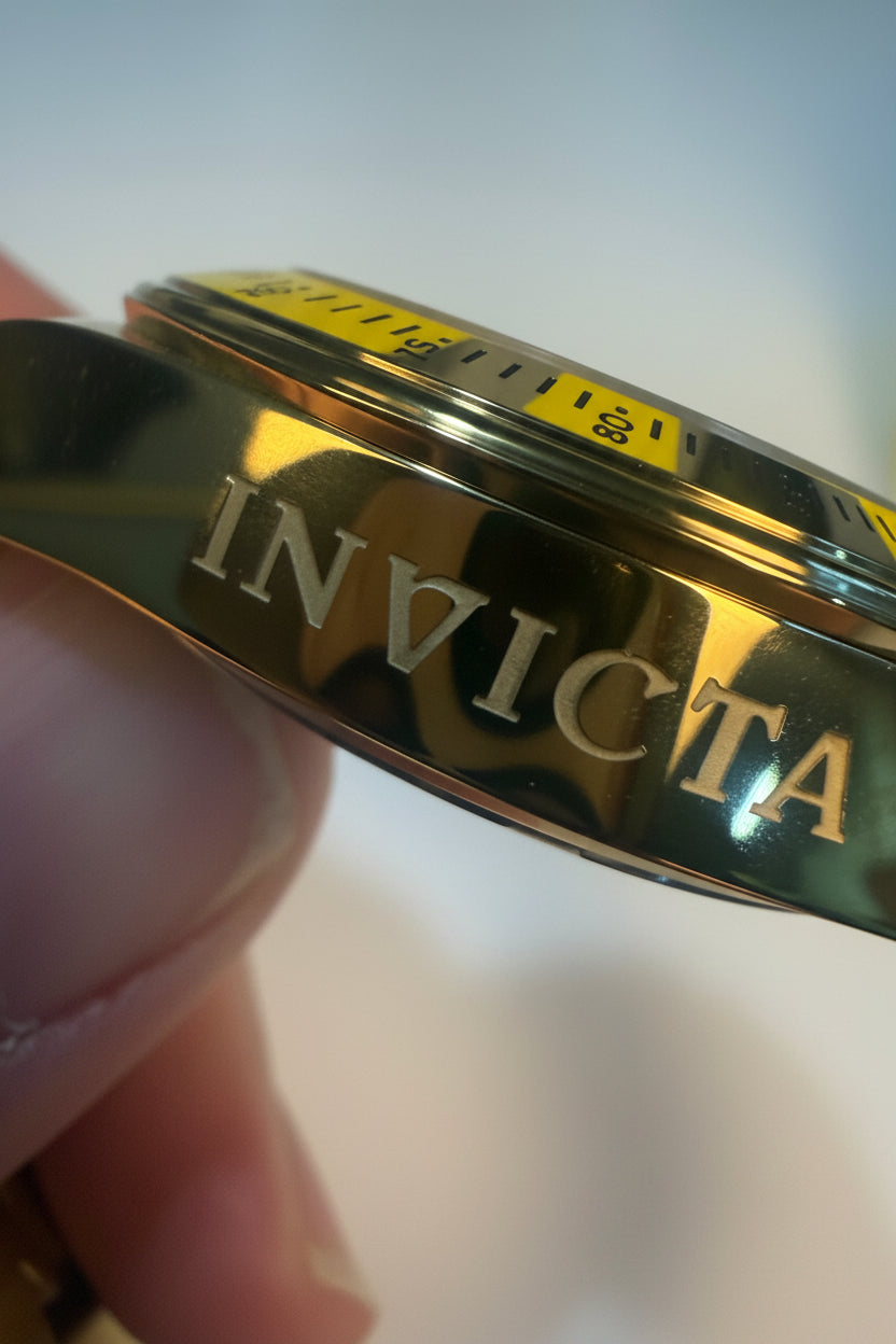 Invicta Speedway Monte Carlo Gold watch band with a blurred background