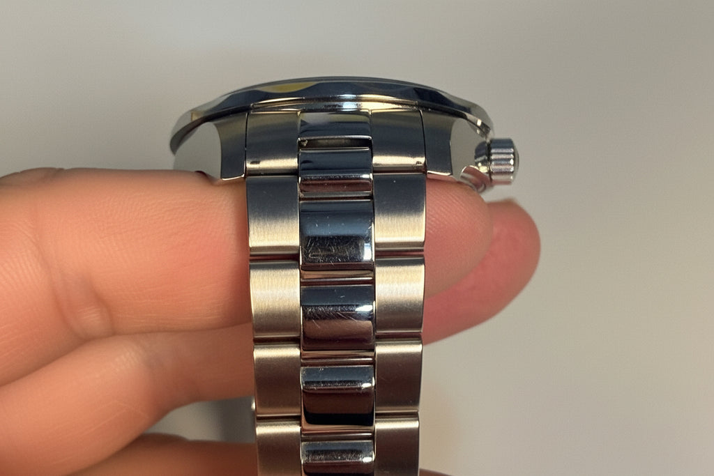 Invicta Silver watch band on a person's wrist with a plain background