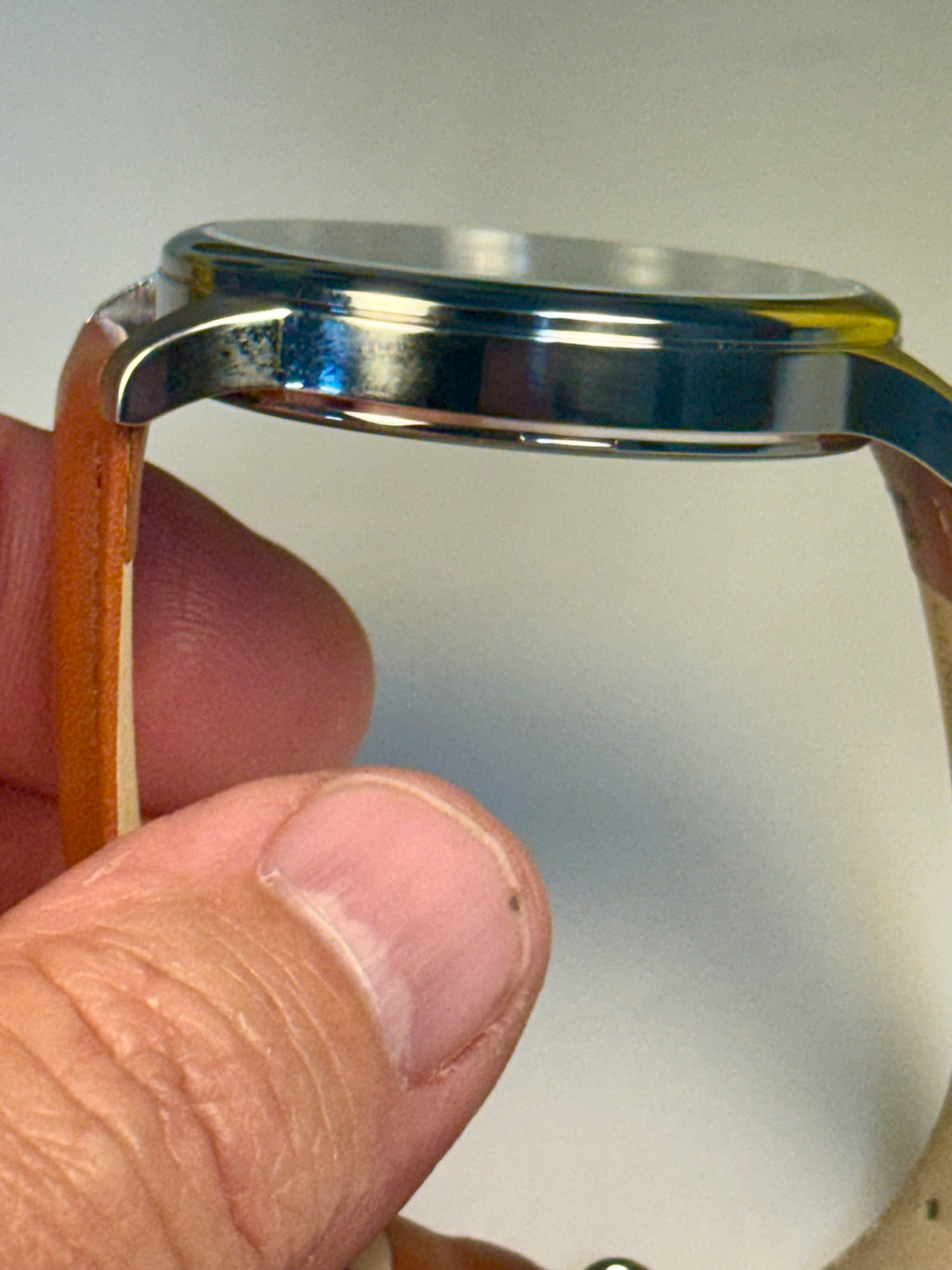 Mens Celestial Blue Sunray Dial Close-up of a watch band being held with a neutral background