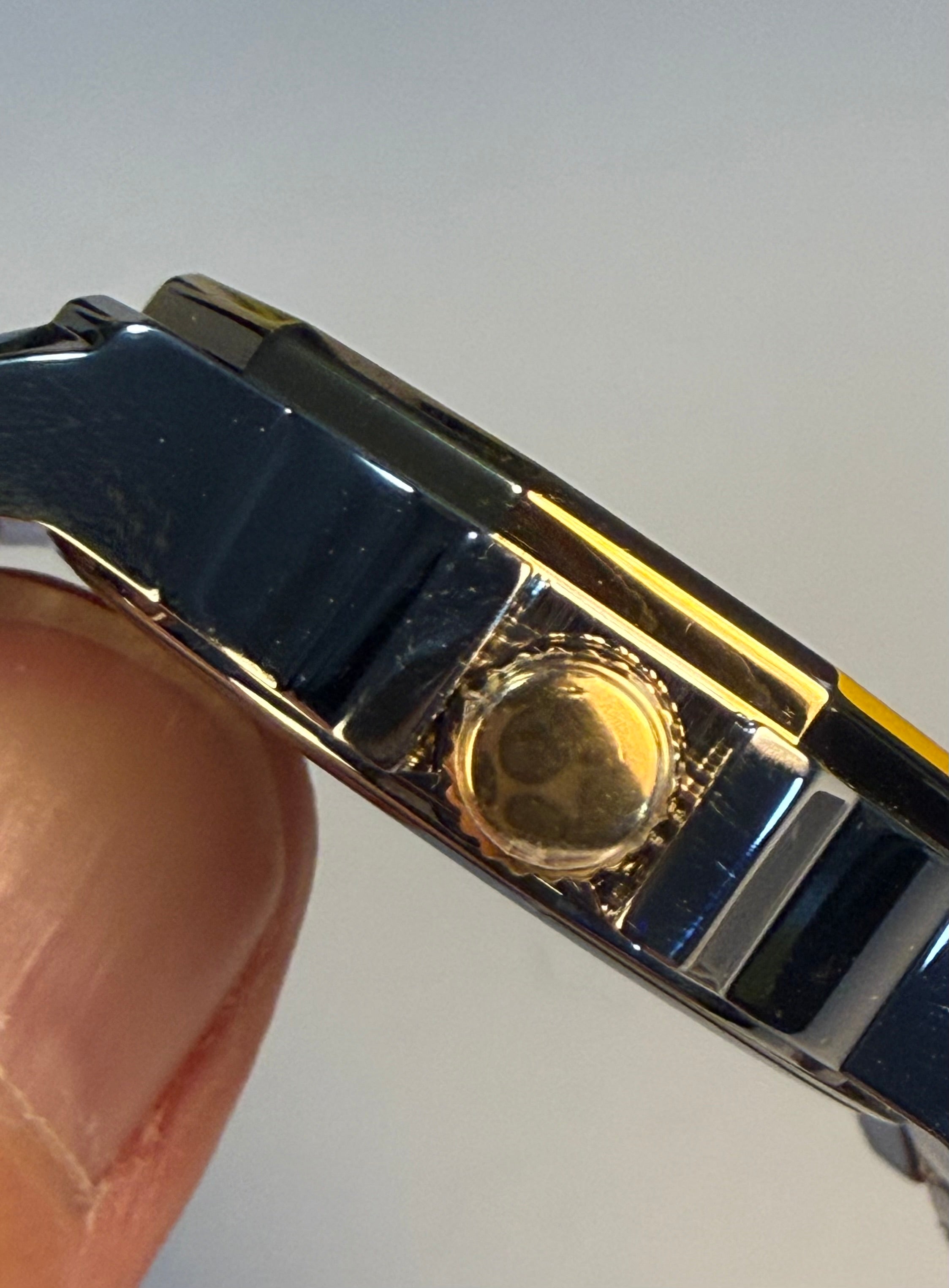Close-up of a Speedway Ladies 34mm Combo with a gold center held by a thumb against a light gray background