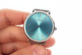 Hand holding an Invicta Angel Starlight  blue Invicta watch against a white background