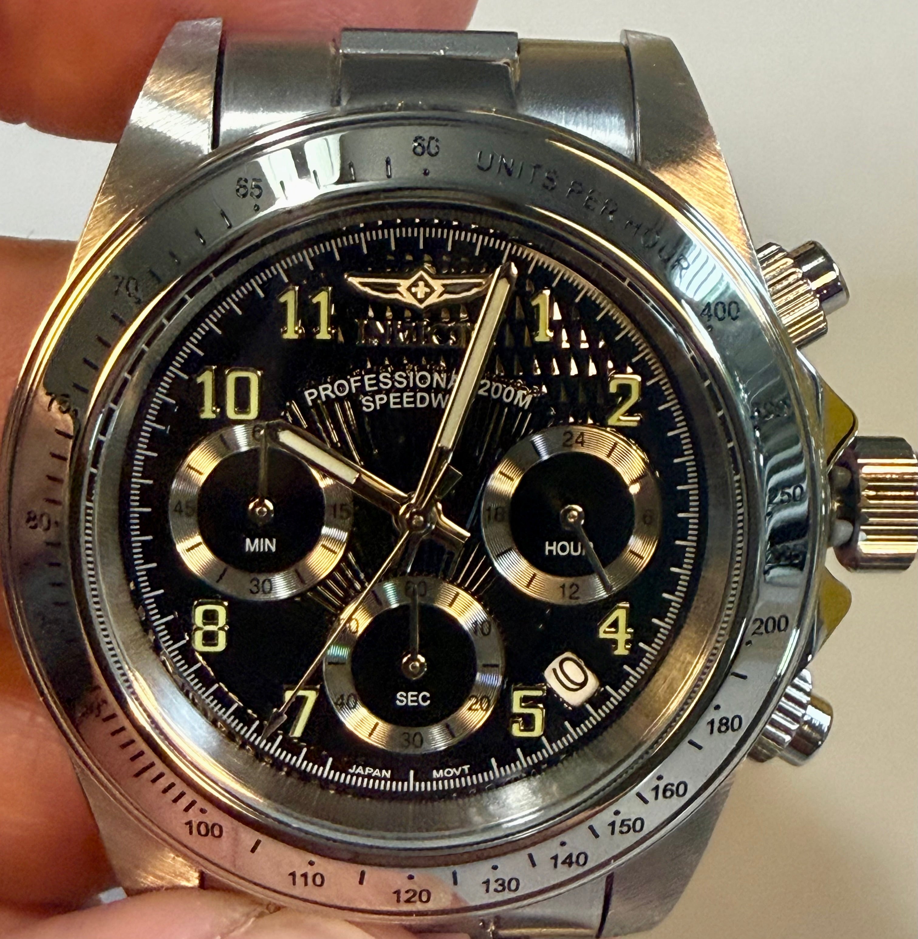 Invicta Speedway Torvane 17025 Men 39.5mm Chrono Steel Watch Black Textured Dialwith detailed face held by a hand