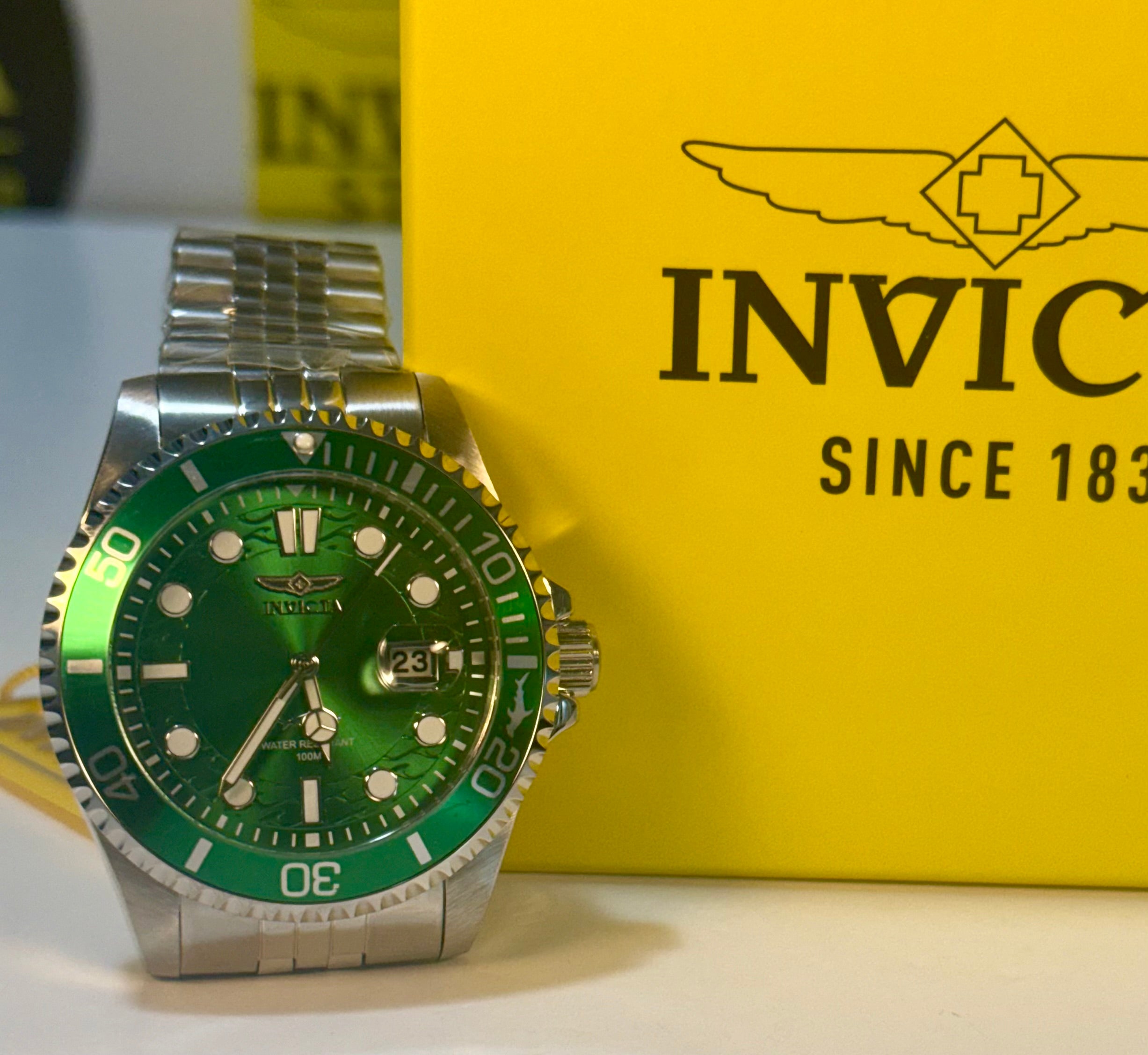Invicta Mens Pro Diver 43mm  Green and silver watch with Invicta packaging in the background