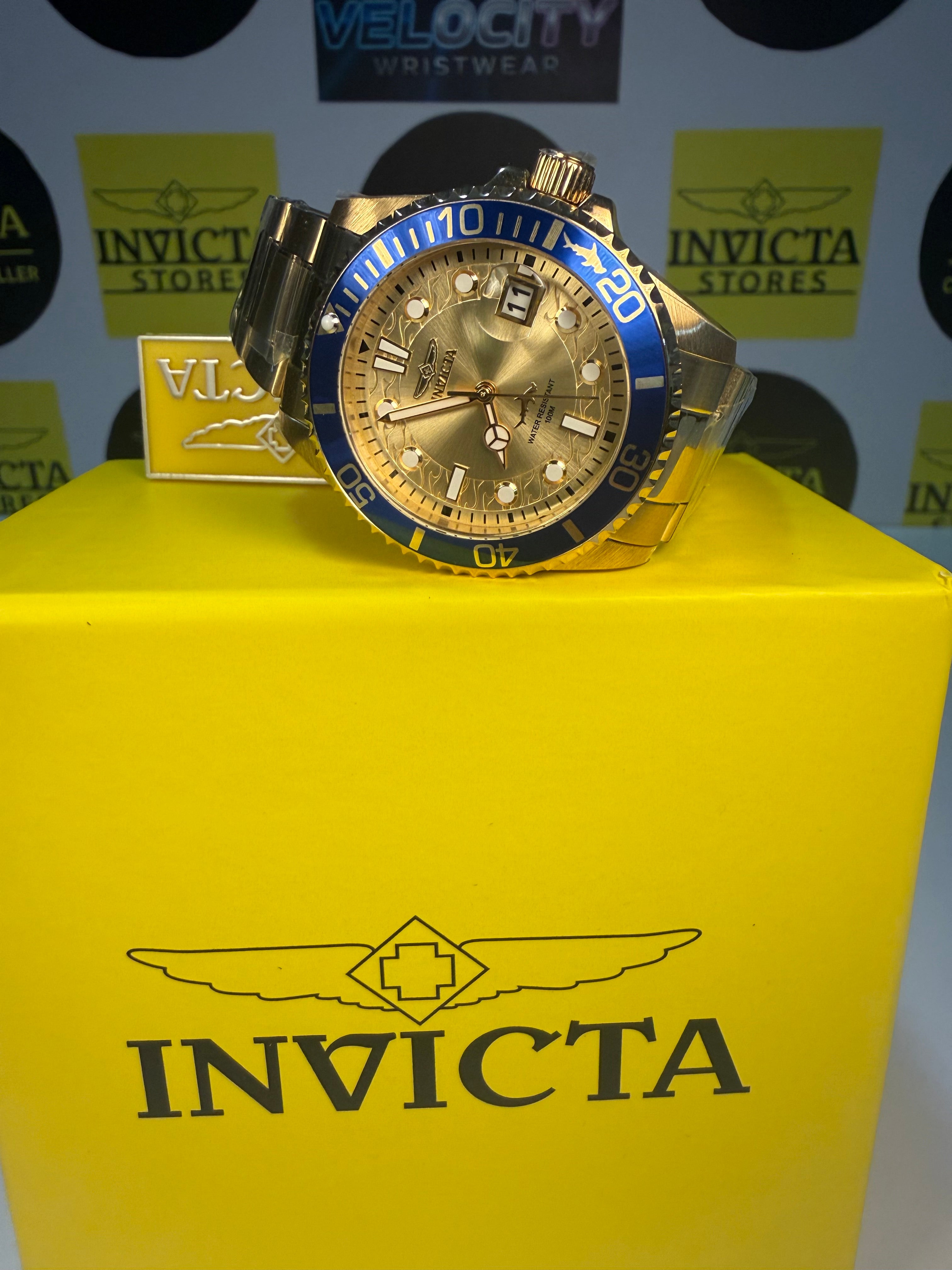 Invicta 38mm Unisex Pro Diver watch on a yellow box with multiple Invicta logos in the background