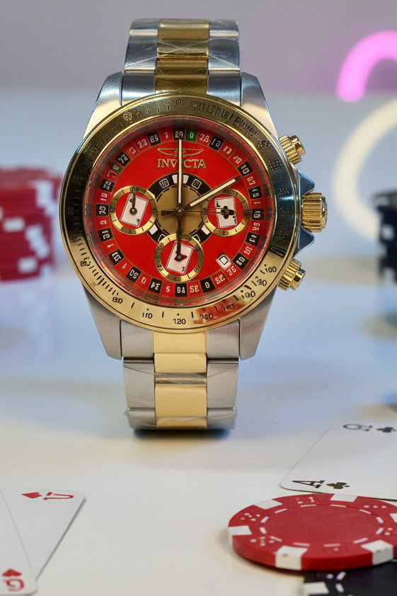 Invicta Speedway Monte Carlo Luxury watch with red face and gold accents on a white surface, with a yellow tag in the background.